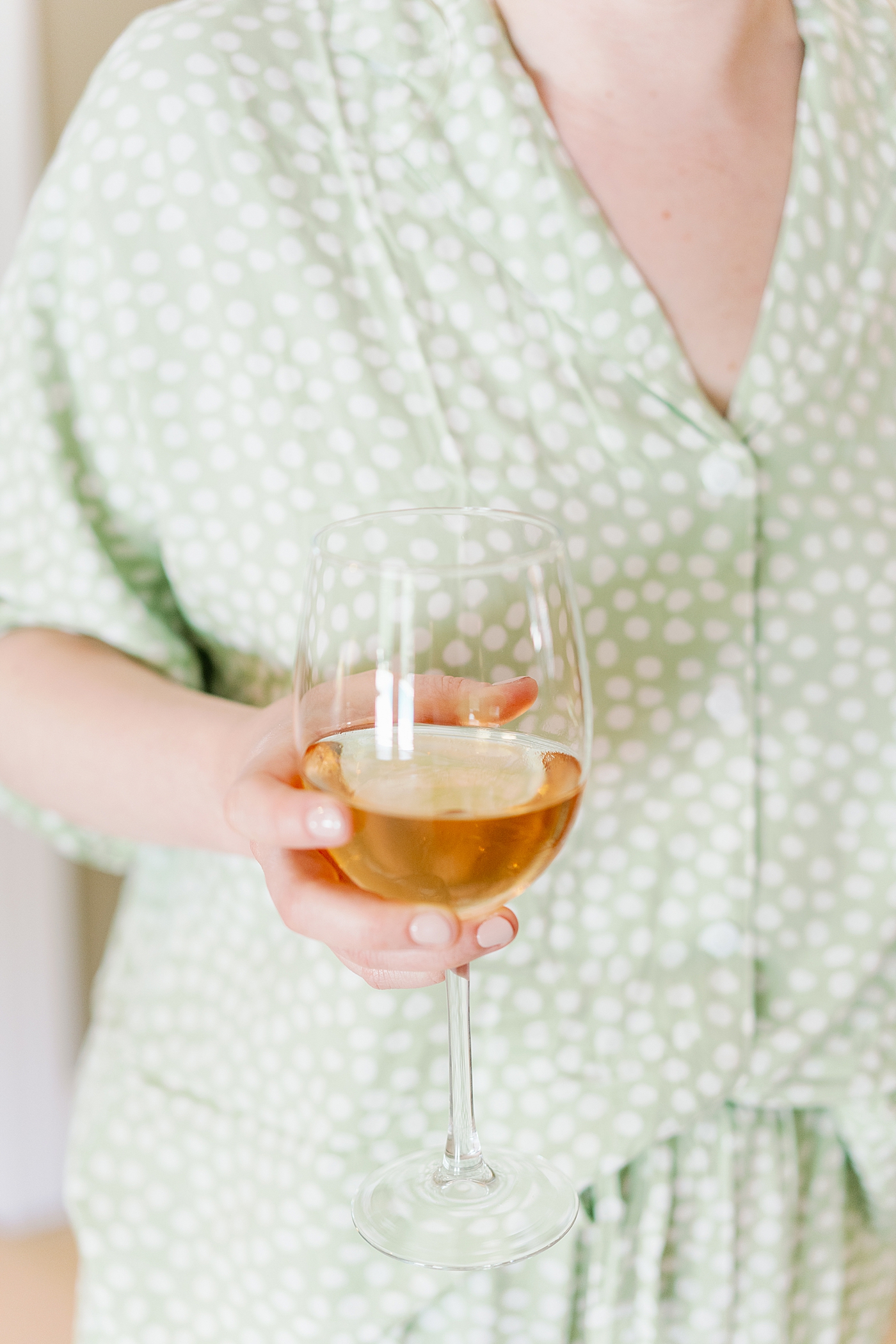 Bridesmaid in green pajamas holding a glass of rose | Photo by Annie Laura Photography