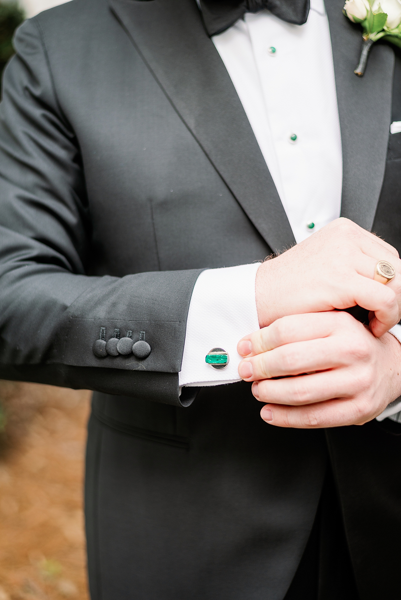 Groom adjusting his green cufflinks | Photo by Annie Laura Photography