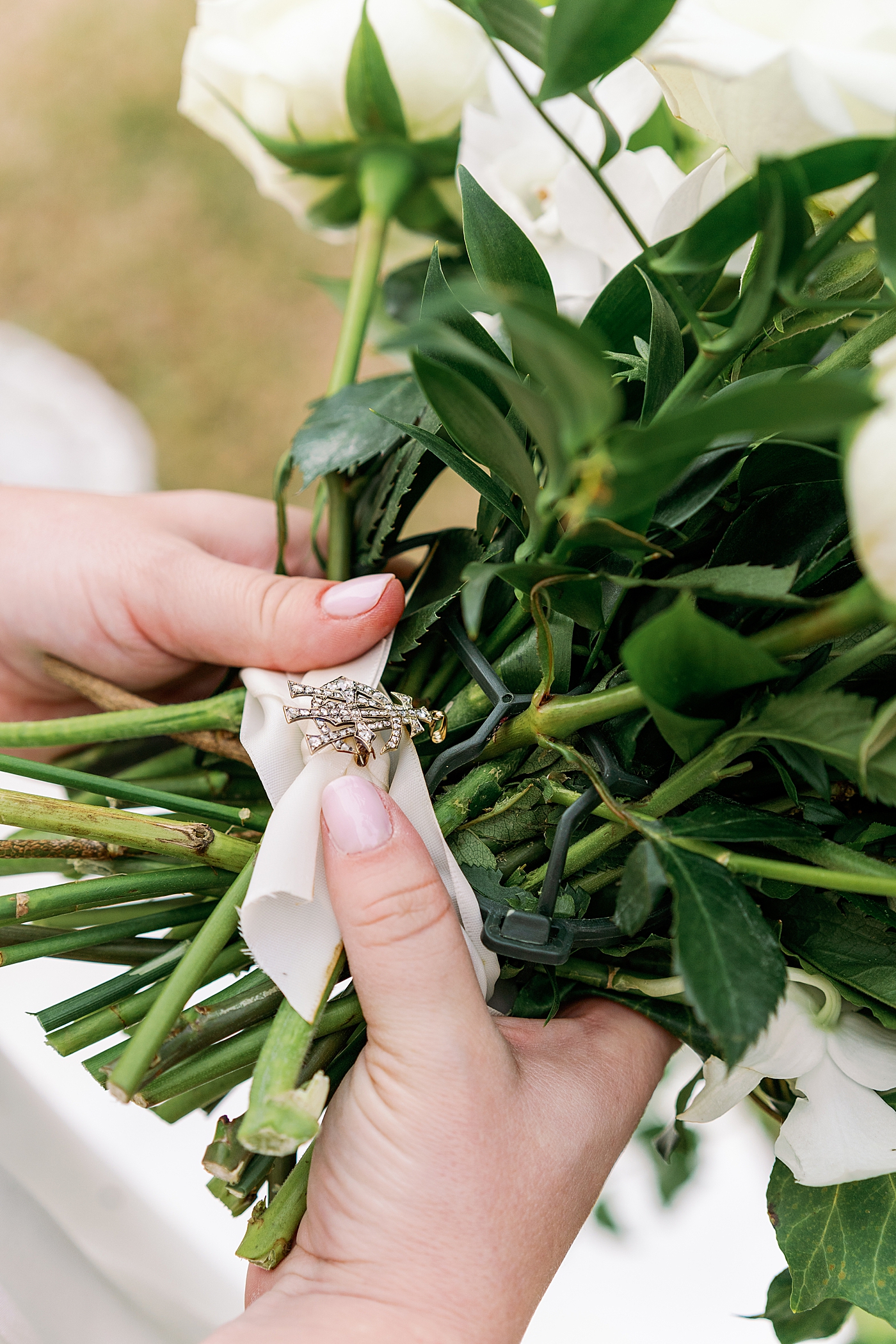 Bride adjusting charm on her bouquet | Photo by Annie Laura Photography