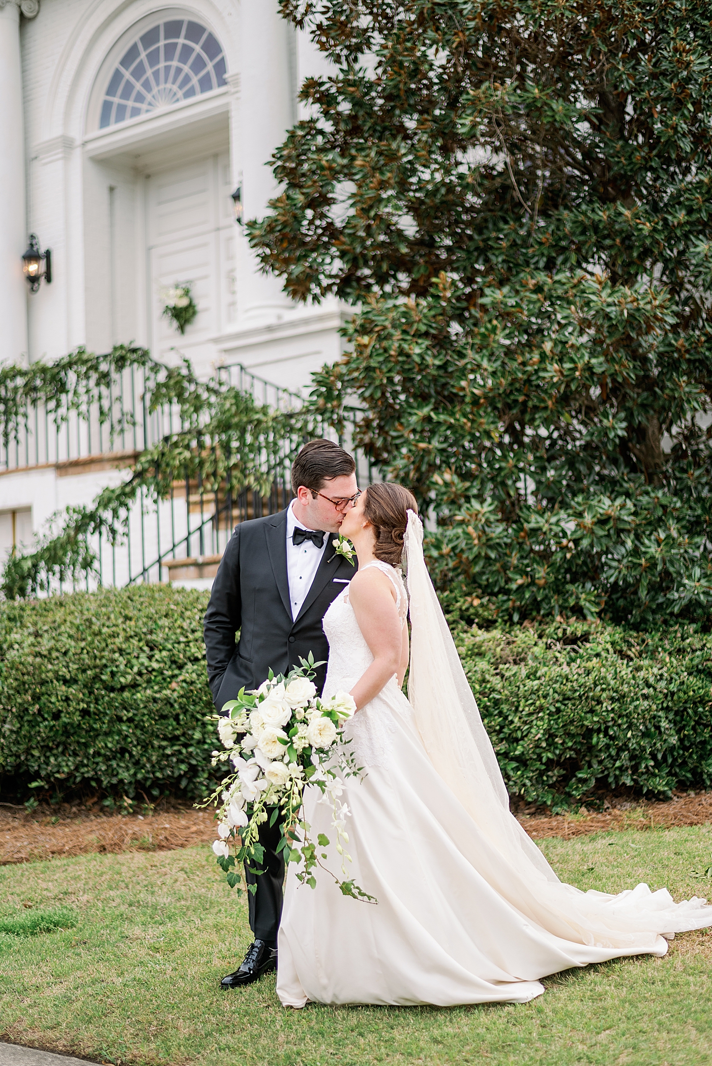Bride and groom kissing walking near a church | Photo by Annie Laura Photography