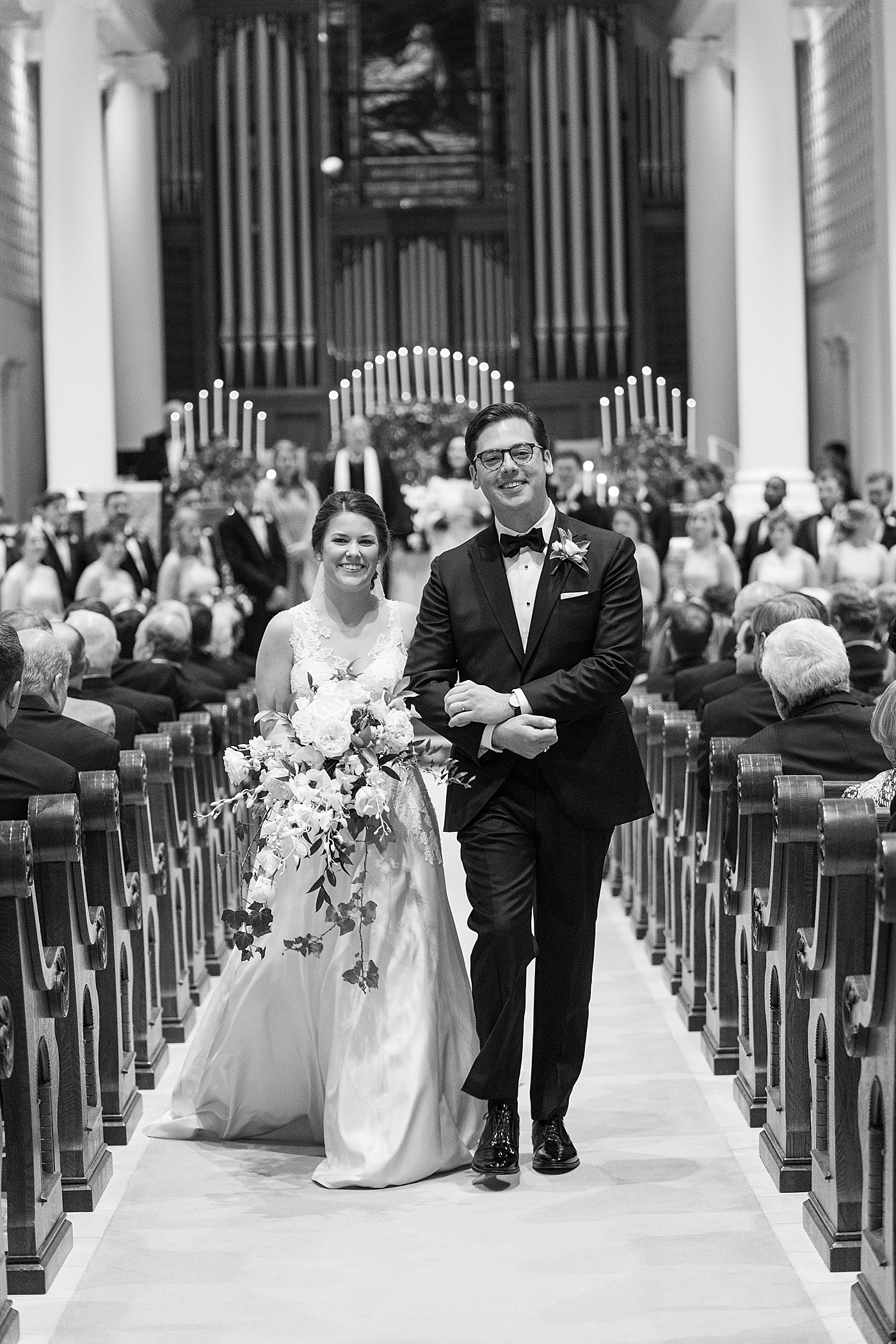 Black and white image of bride and groom walking down the aisle after their wedding | Photo by Annie Laura Photography