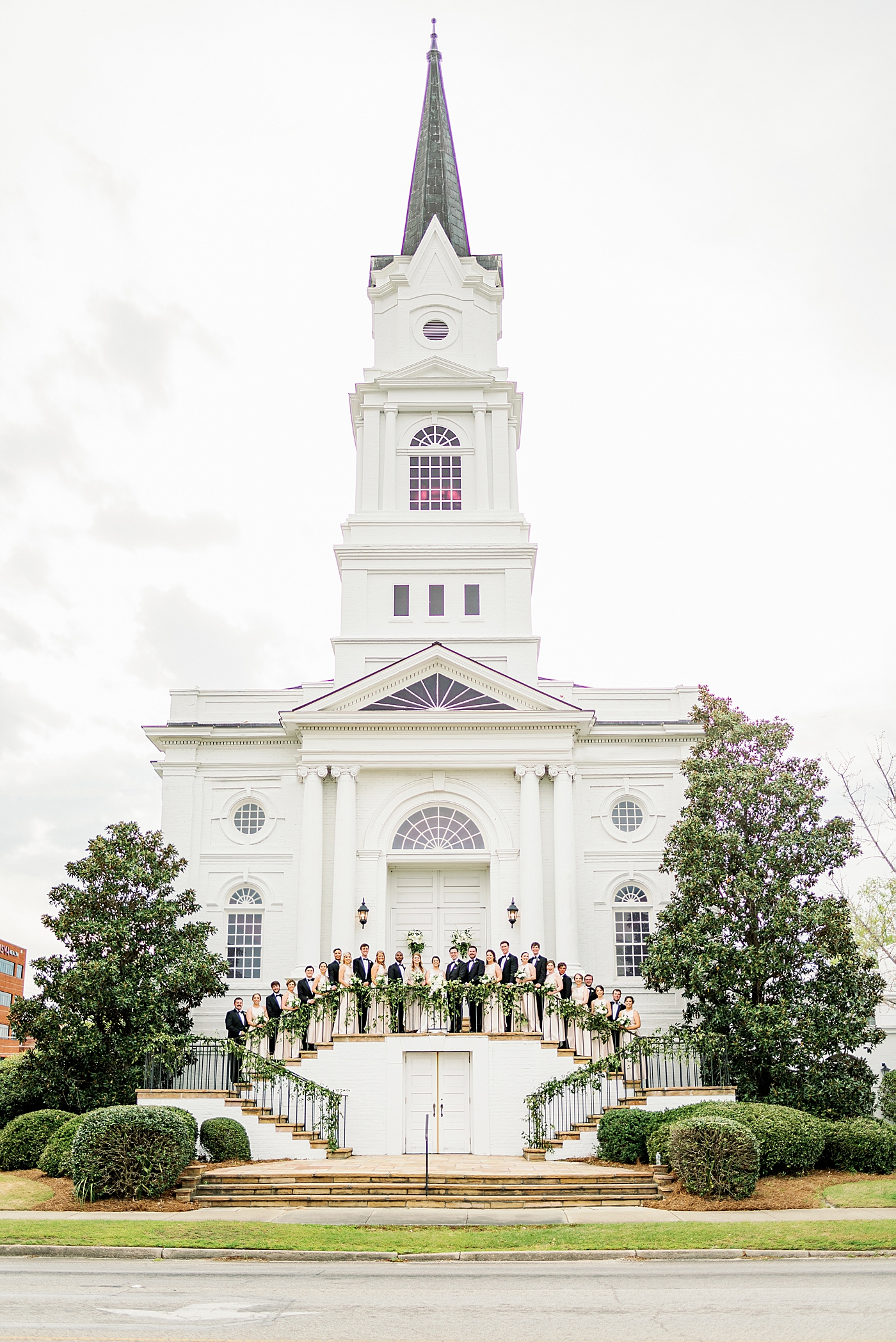 Wedding party posing on the steps of a church | Photo by Annie Laura Photography