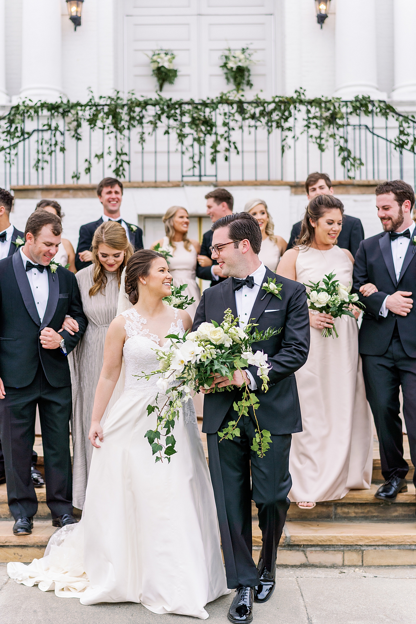 Bride and groom walking with their wedding party during their Timeless Country Club Wedding | Photo by Annie Laura Photography