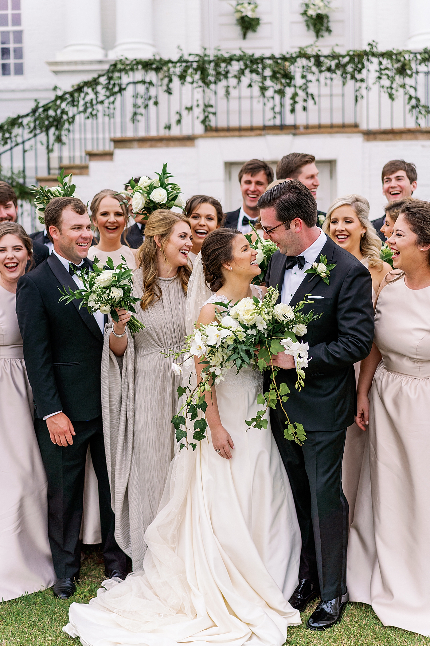 Bride and groom laughing together with their bridal party during their Timeless Country Club Wedding | Photo by Annie Laura Photography