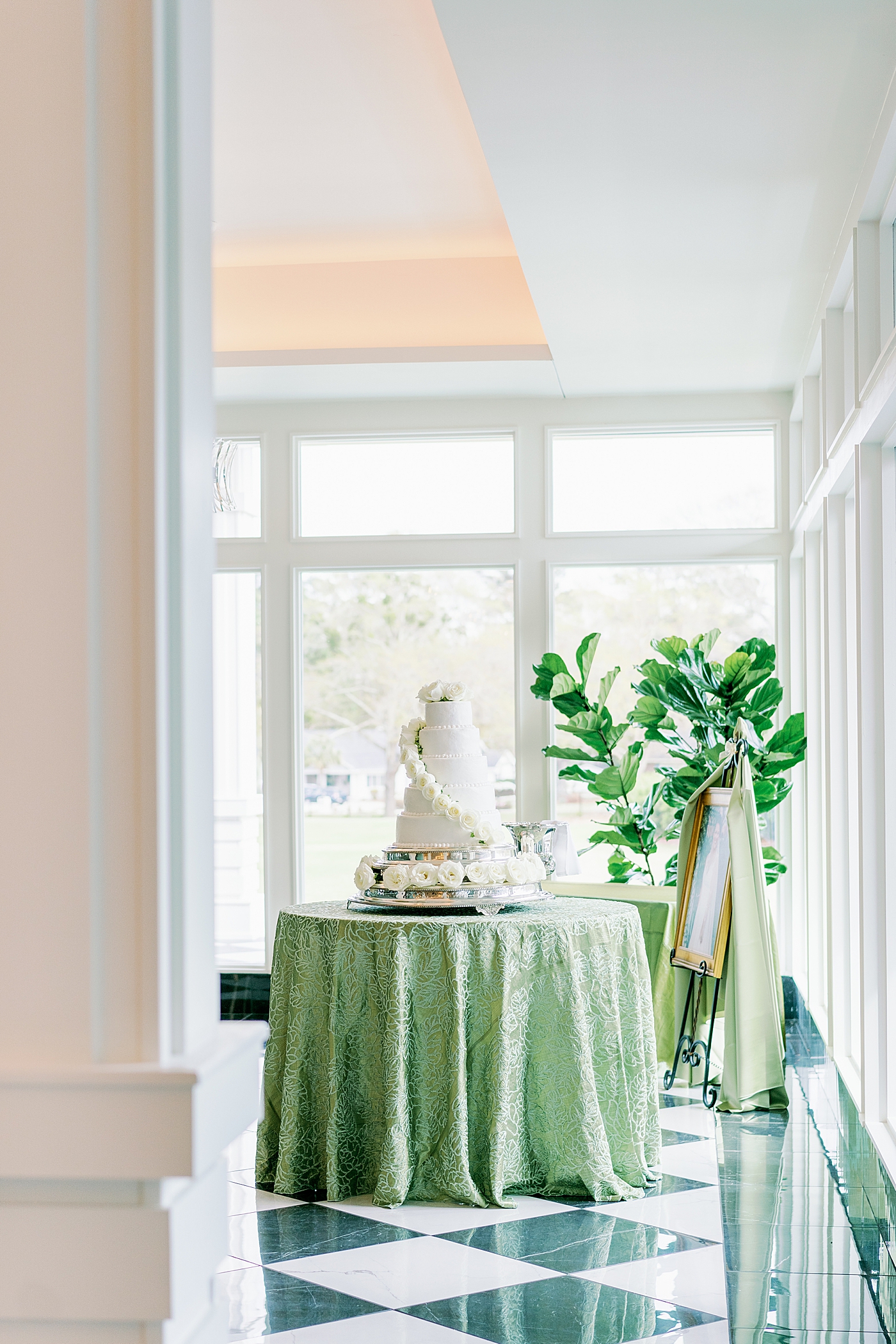 Wedding cake on a table with green table cloth during Timeless Country Club Wedding | Photo by Annie Laura Photography