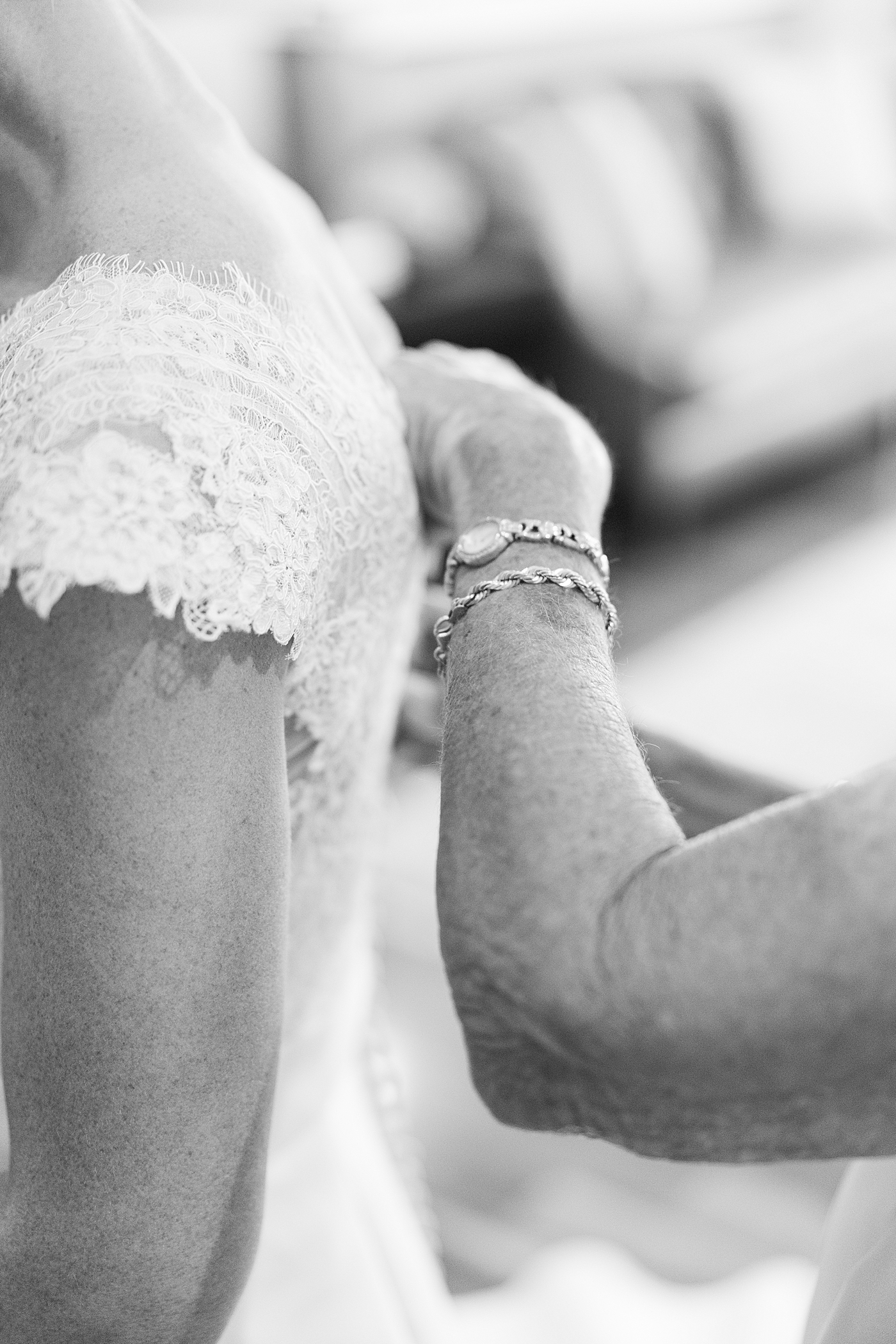Black and white image of mother of bride buttoning the dress | Image by Annie Laura Photo