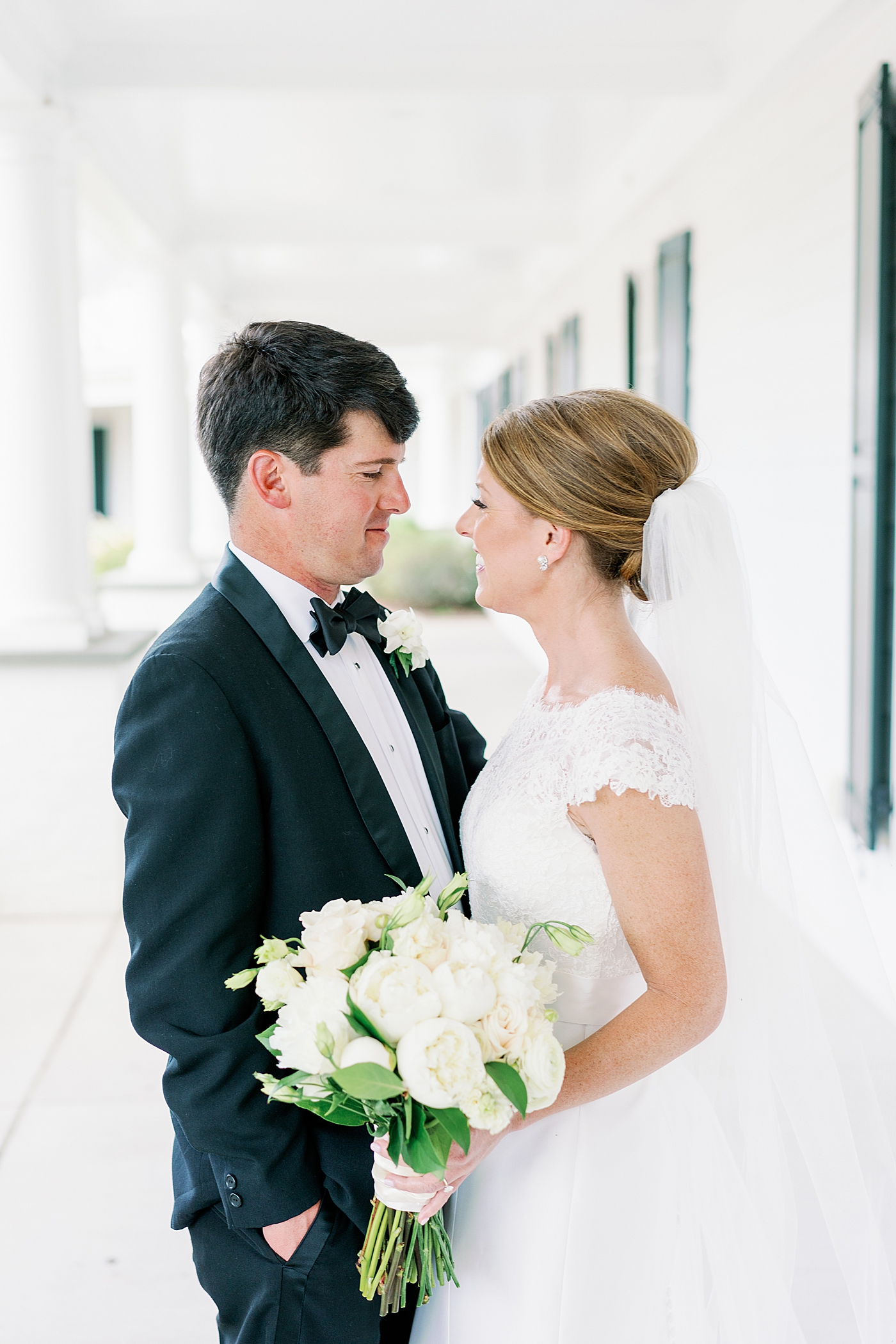 Bride and groom smiling together on a porch | Image by Annie Laura Photo