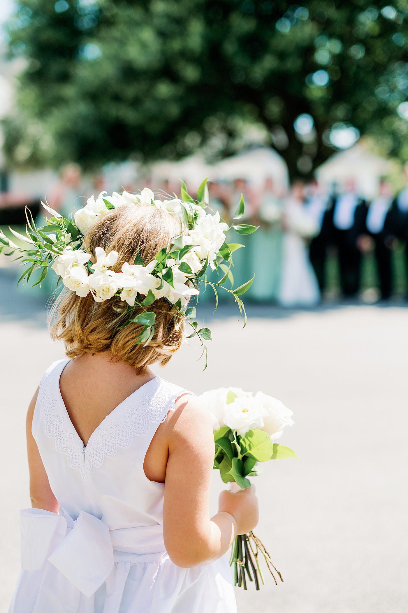 Flower girl with a flower crown holding a bouquet | Image by Annie Laura Photo