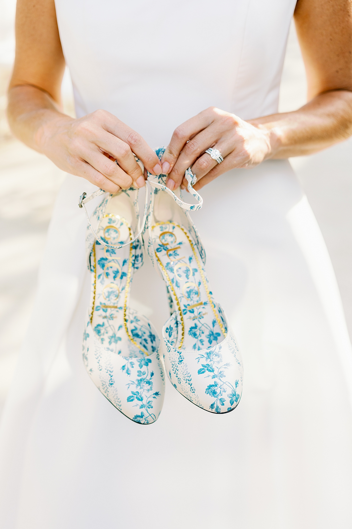 Bride holding blue floral print Gucci shoes | Photo by Annie Laura Photo