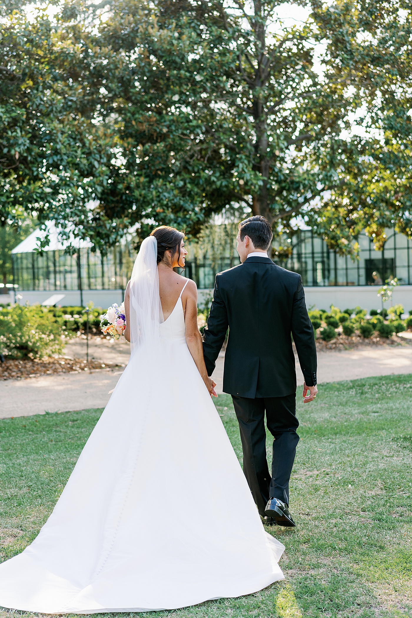 Bride and groom walking together during summer inspired garden wedding | Photo by Annie Laura Photo