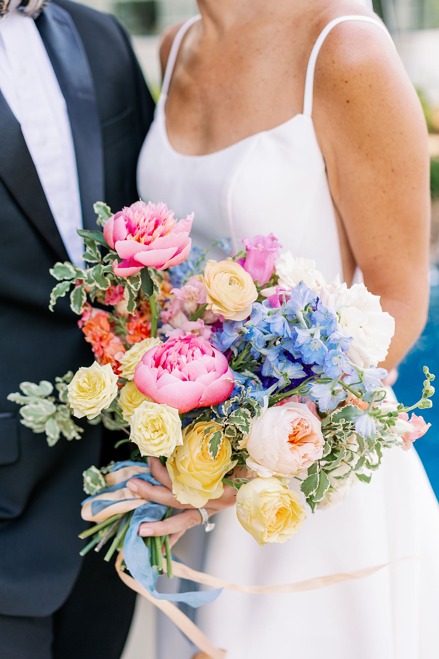Colorful bridal bouquet held by bride | Photo by Annie Laura Photo