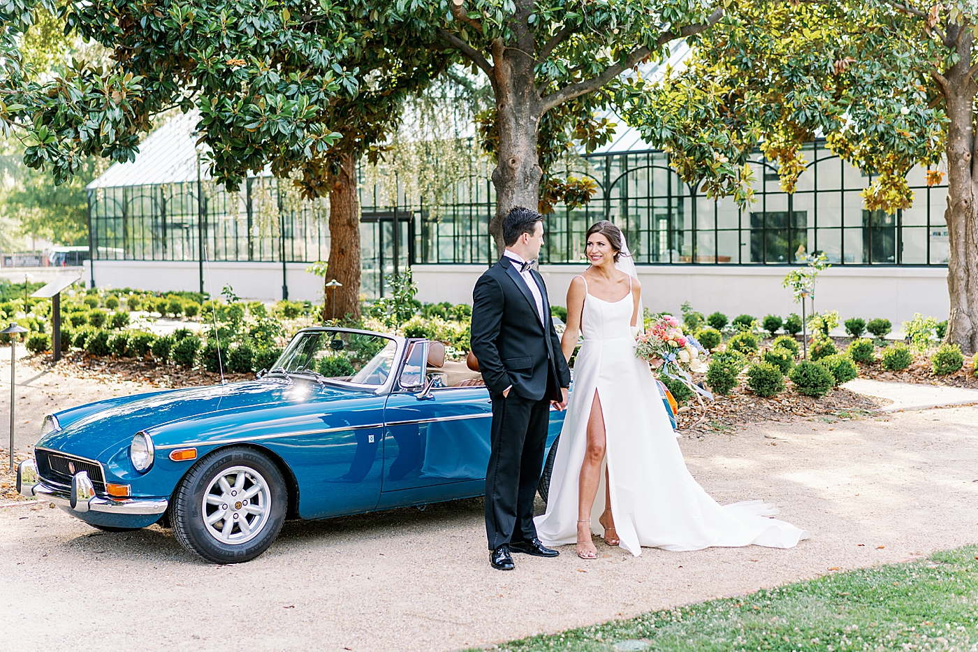Bride and groom posing by blue antique car | Photo by Annie Laura Photo