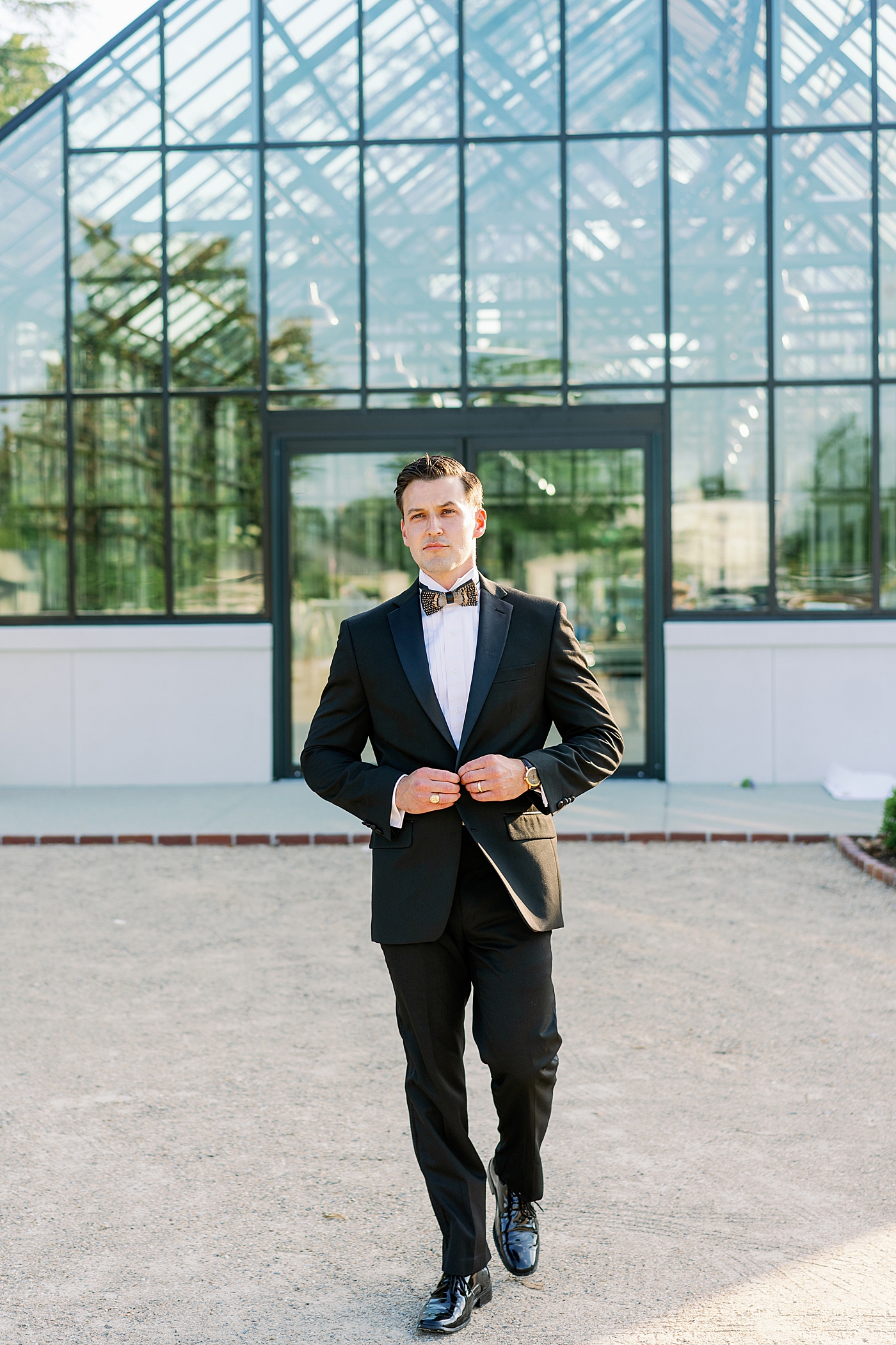 Groom buttoning his jacket in front of Boyd Foundation Horticultural Center | Photo by Annie Laura Photo