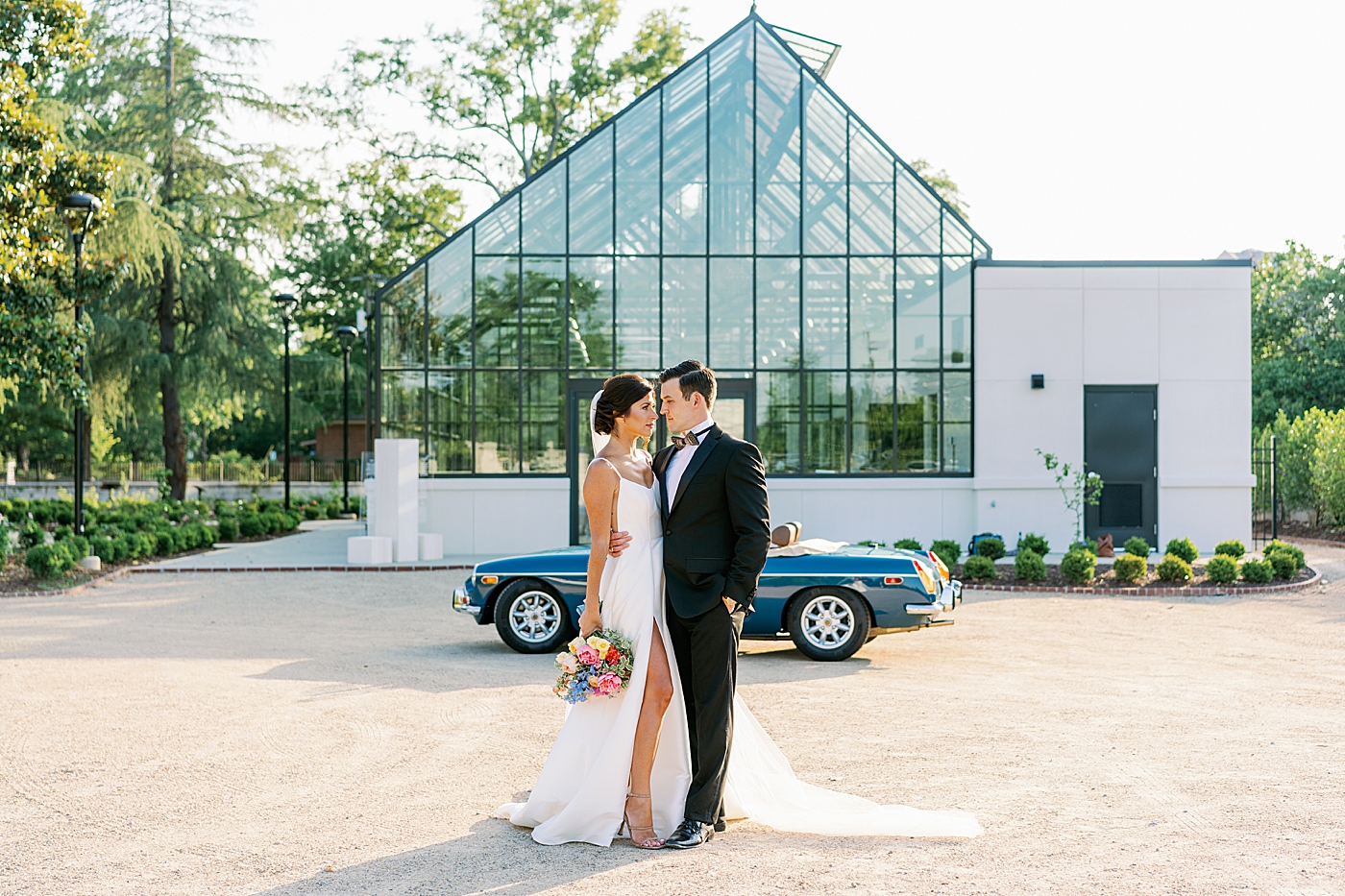 Bride and groom snuggling in front of Boyd Foundation Horticultural Center | Photo by Annie Laura Photo