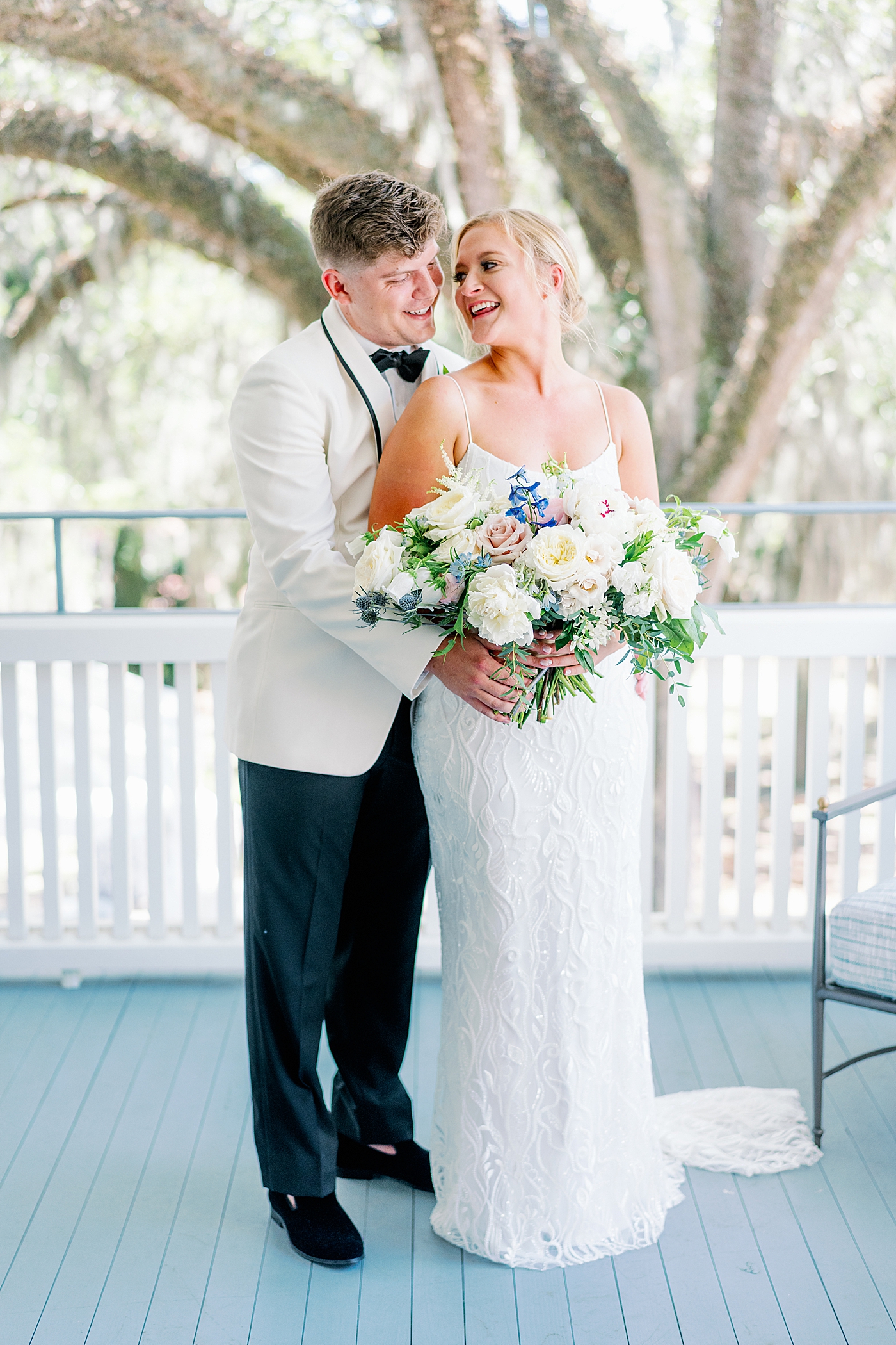Bride and groom embracing on a balcony during their Elegant Grandmillenial Charleston Wedding | Images by Annie Laura Photography