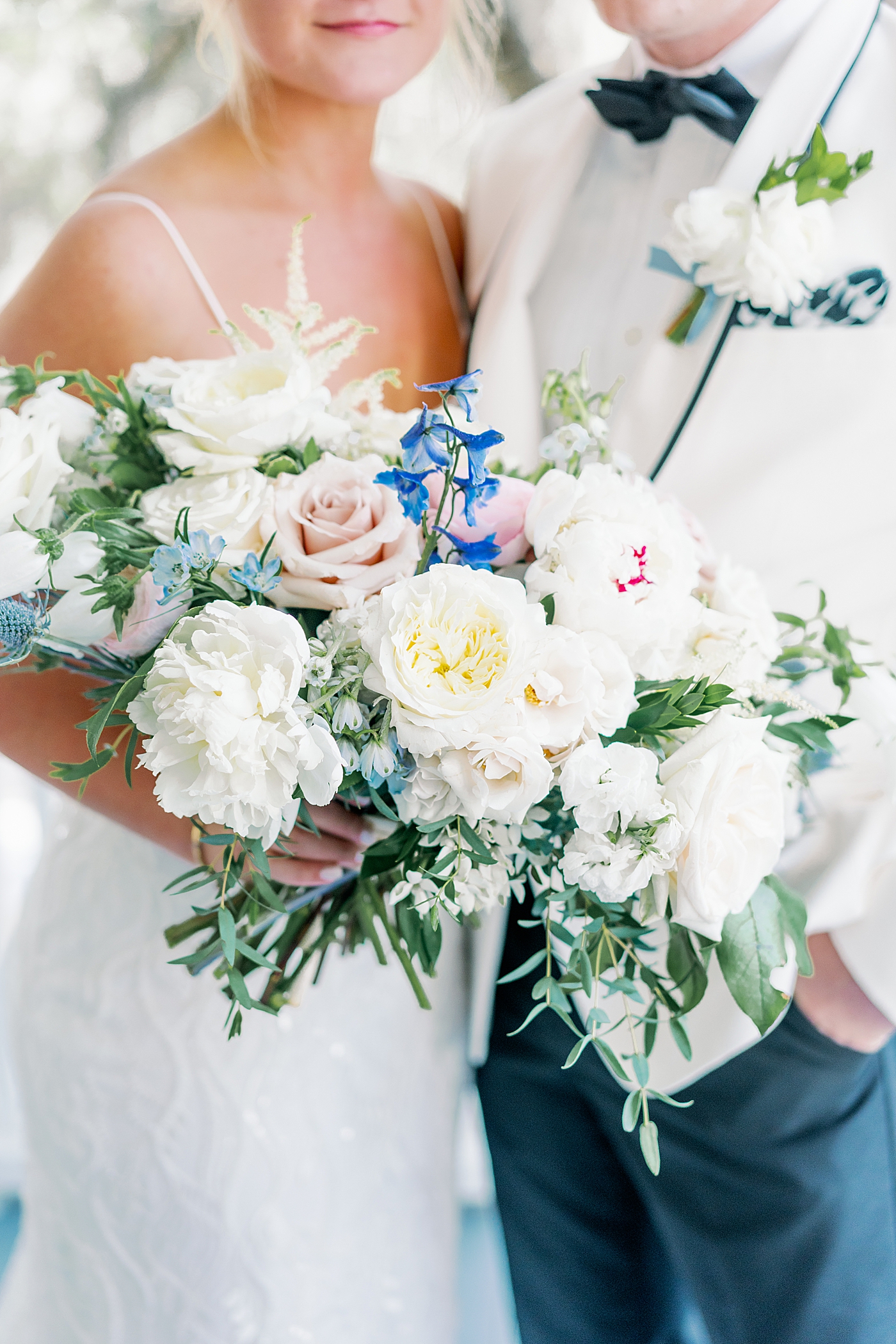 Bridal bouquet held by bride and groom during their Elegant Grandmillenial Charleston Wedding | Images by Annie Laura Photography