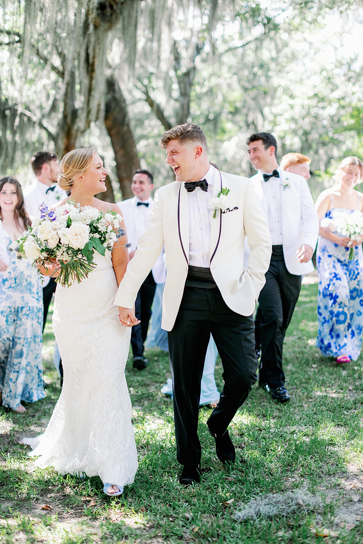 Bride and groom walking with their bridal party during their Elegant Grandmillenial Charleston Wedding | Images by Annie Laura Photography