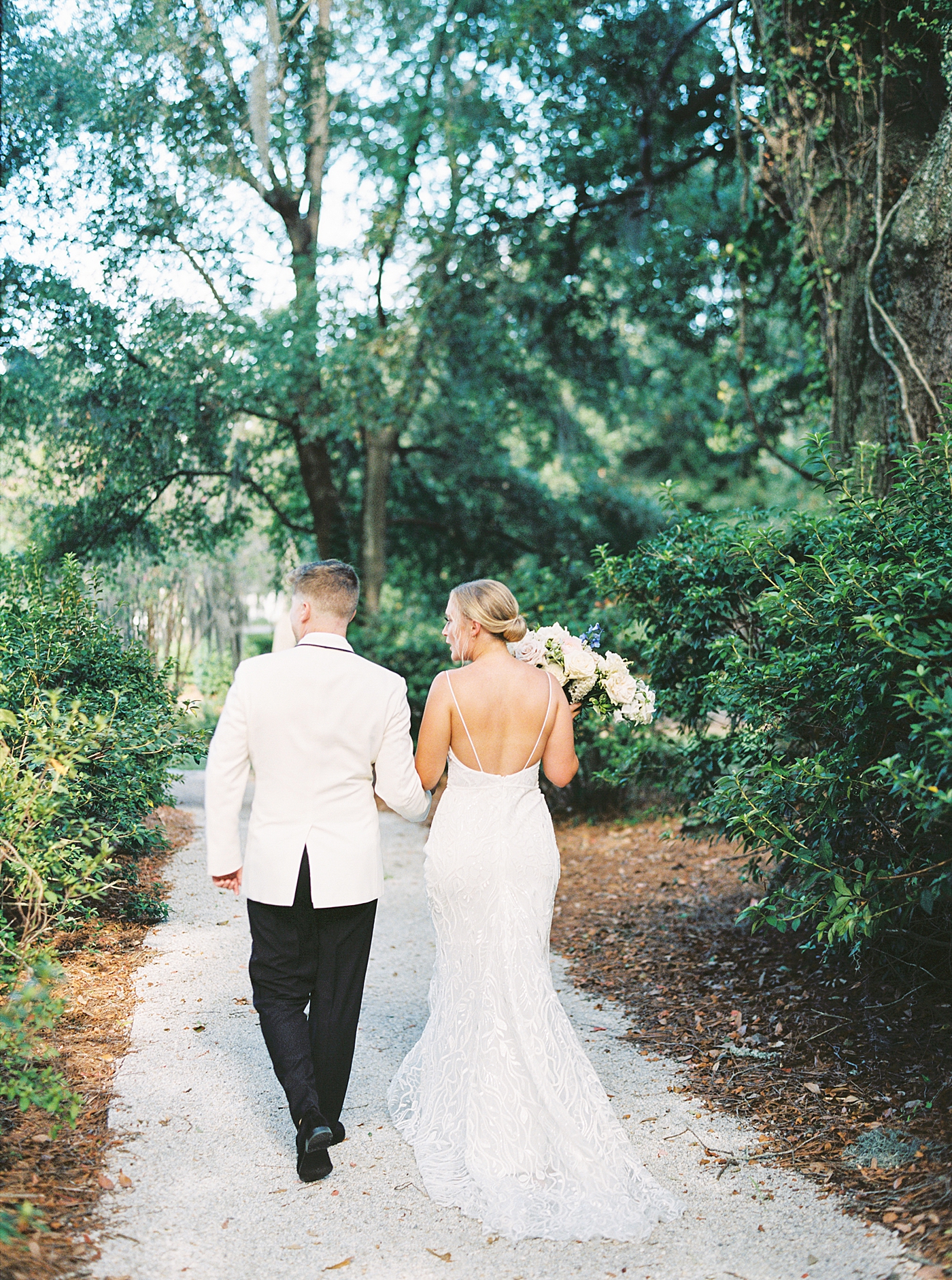 Bride and groom walking to their reception during their Elegant Grandmillenial Charleston Wedding | Images by Annie Laura Photography