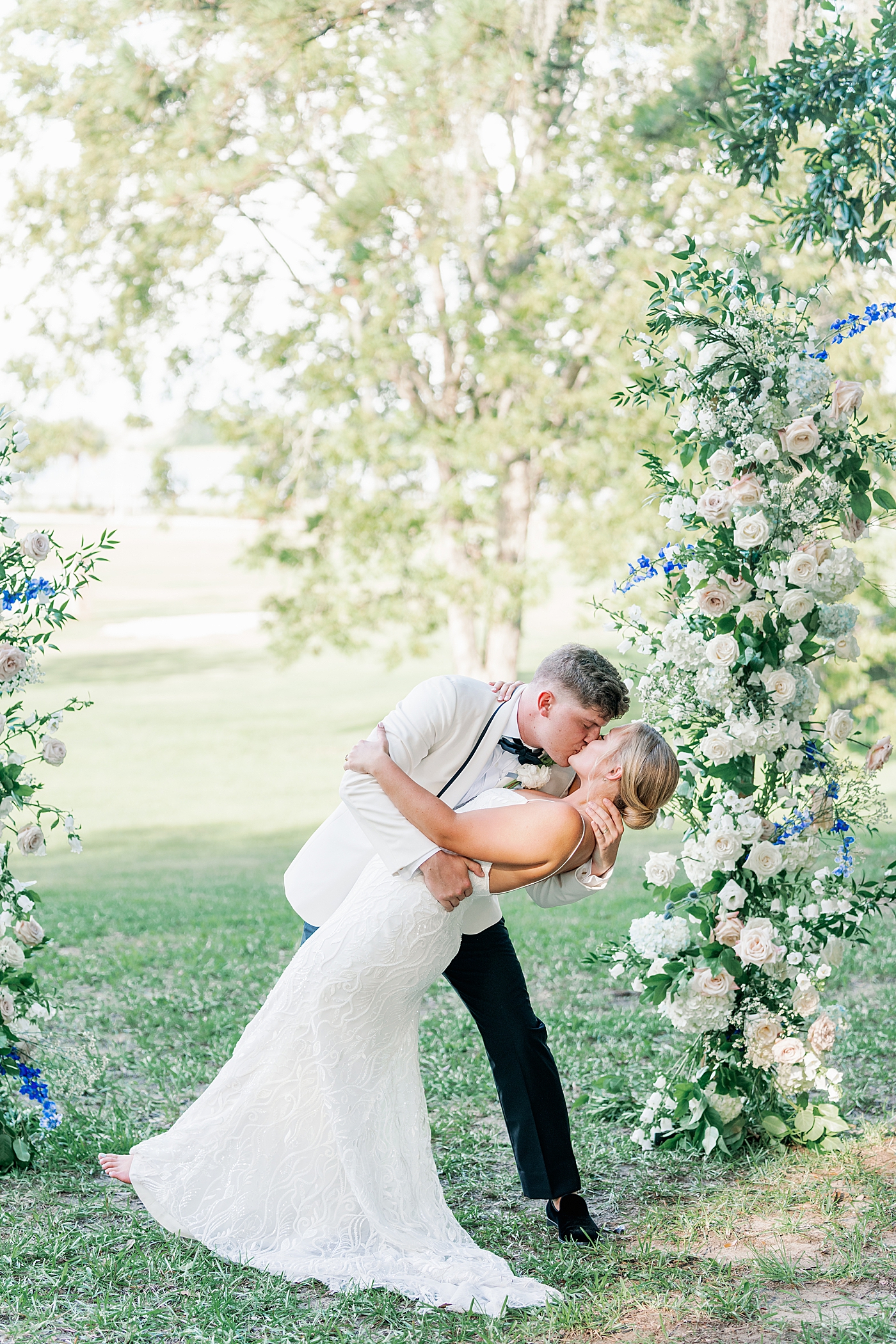 Groom dipping bride under arbor during their Elegant Grandmillenial Charleston Wedding | Images by Annie Laura Photography