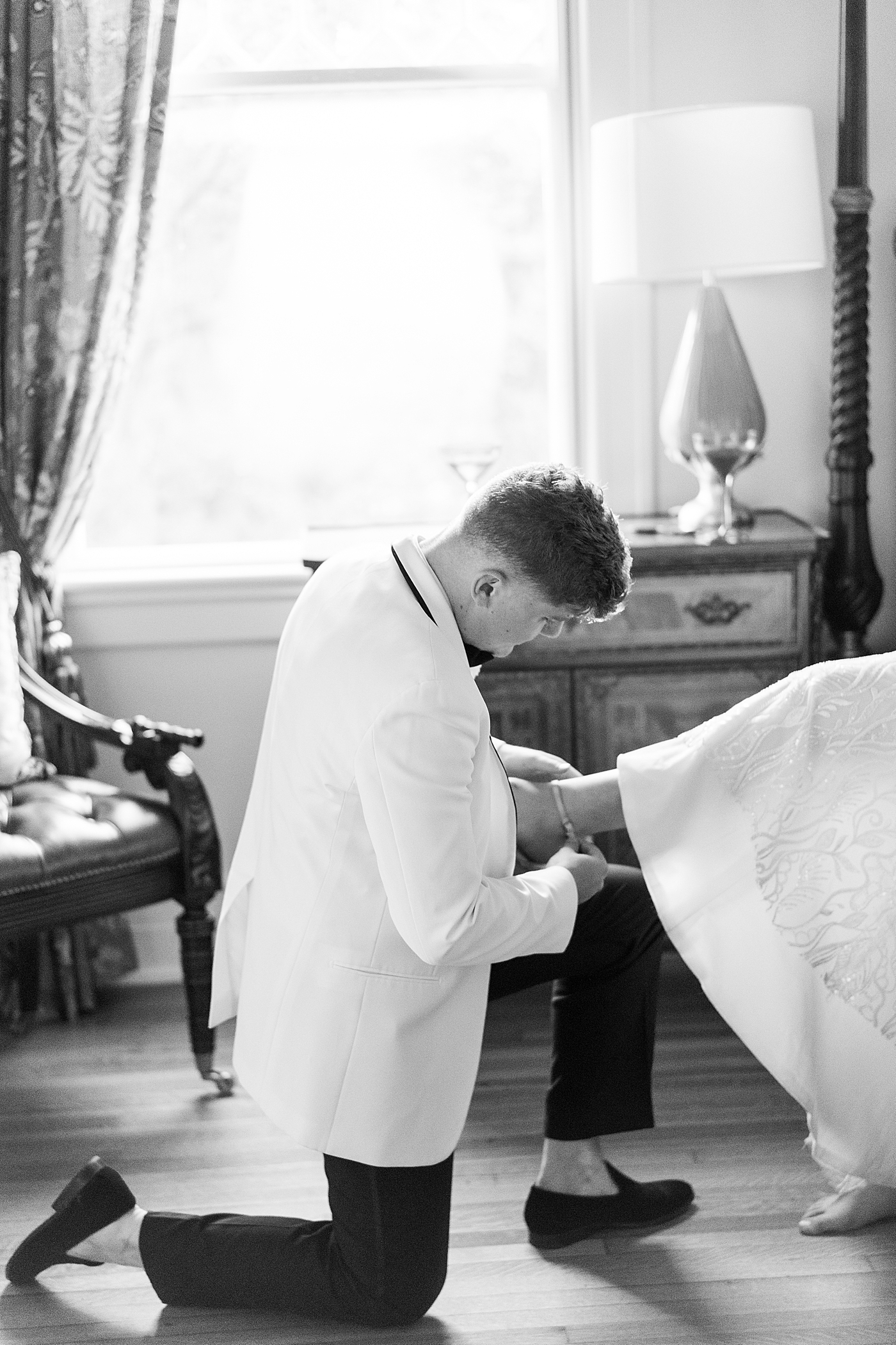 Groom helping bride with her shoes during their Elegant Grandmillenial Charleston Wedding | Images by Annie Laura Photography