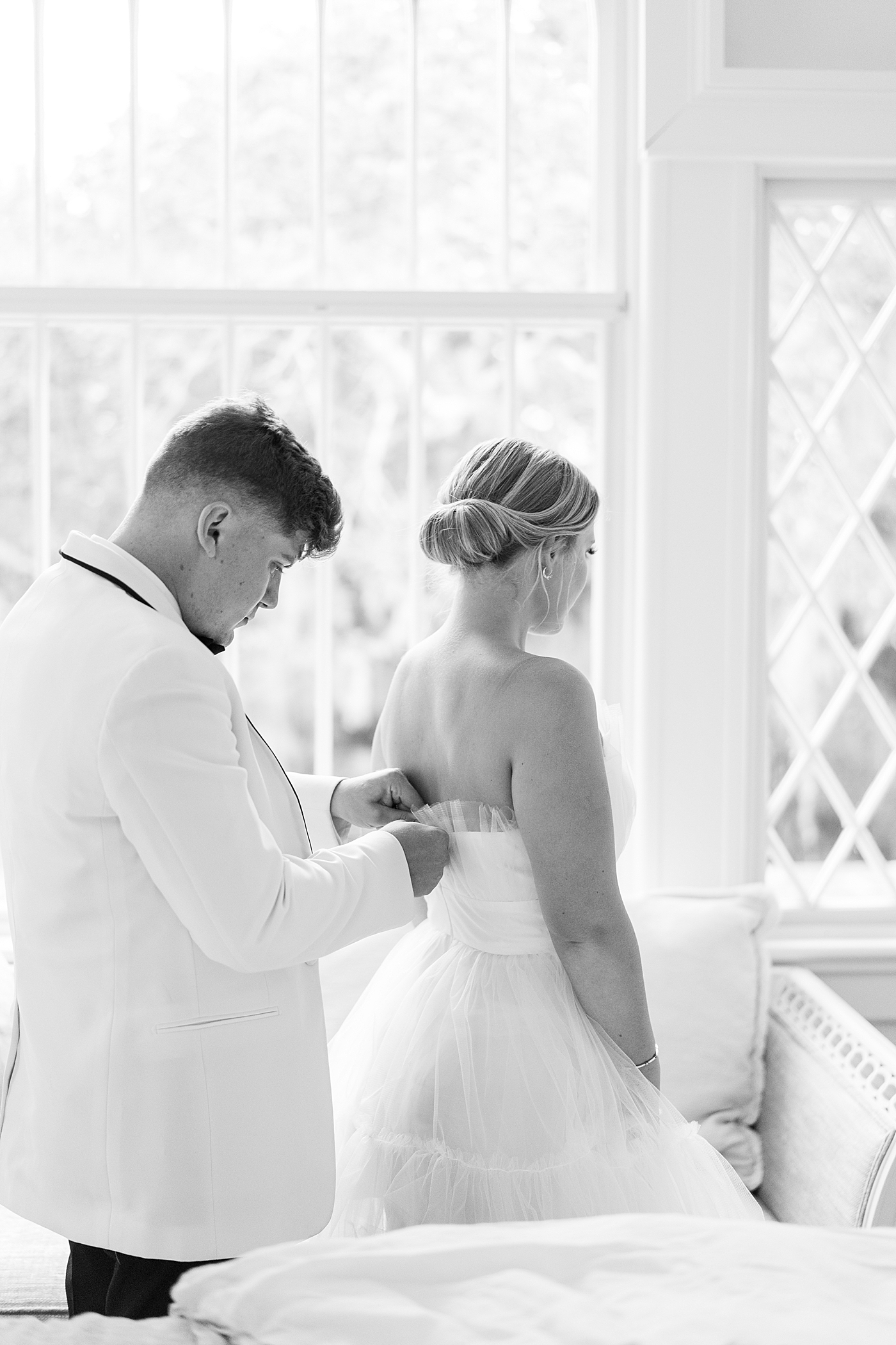 Groom zipping brides dress for reception | Images by Annie Laura Photography