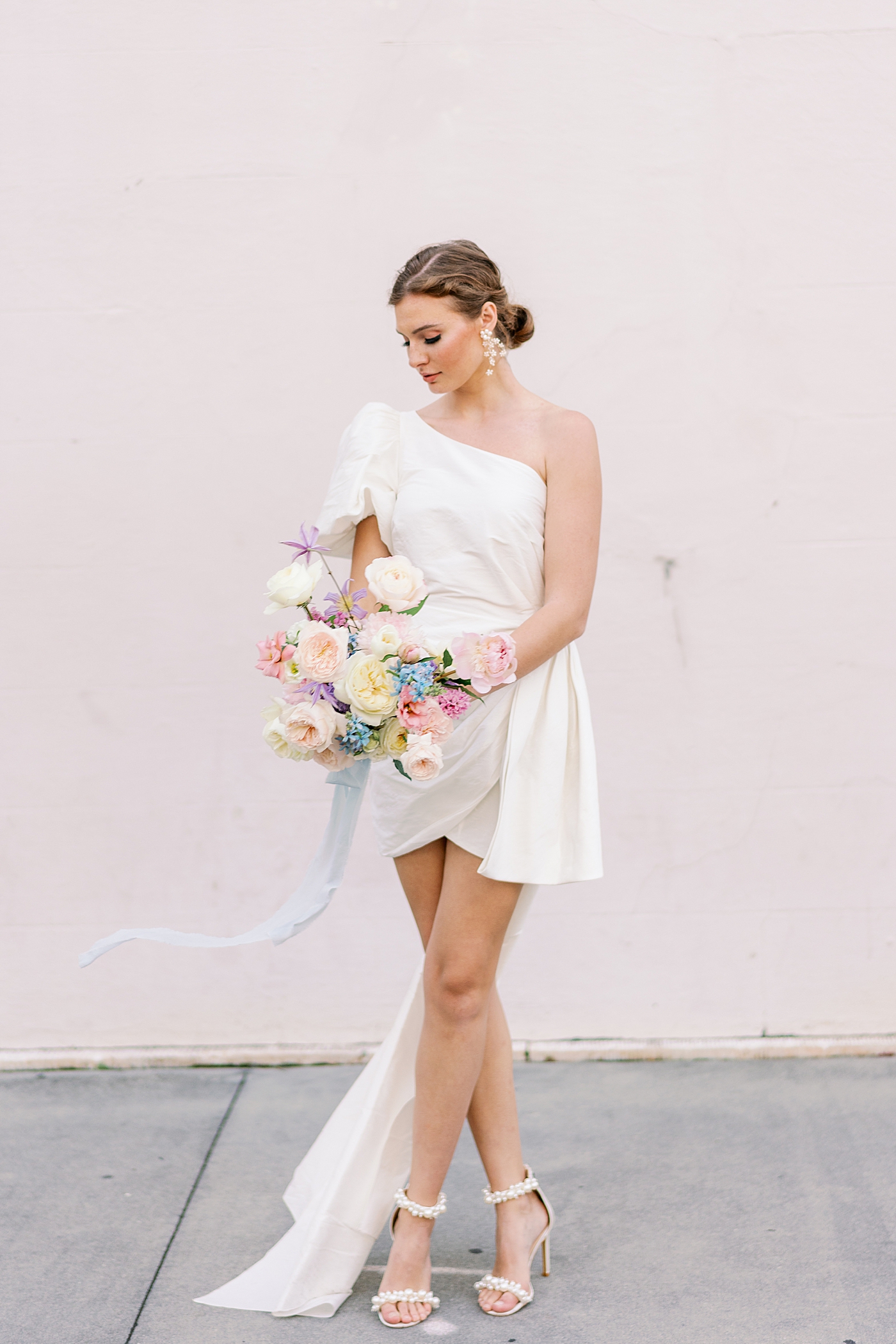 Bride with pastel bouquet in front of pink wall | Images by Annie Laura Photo