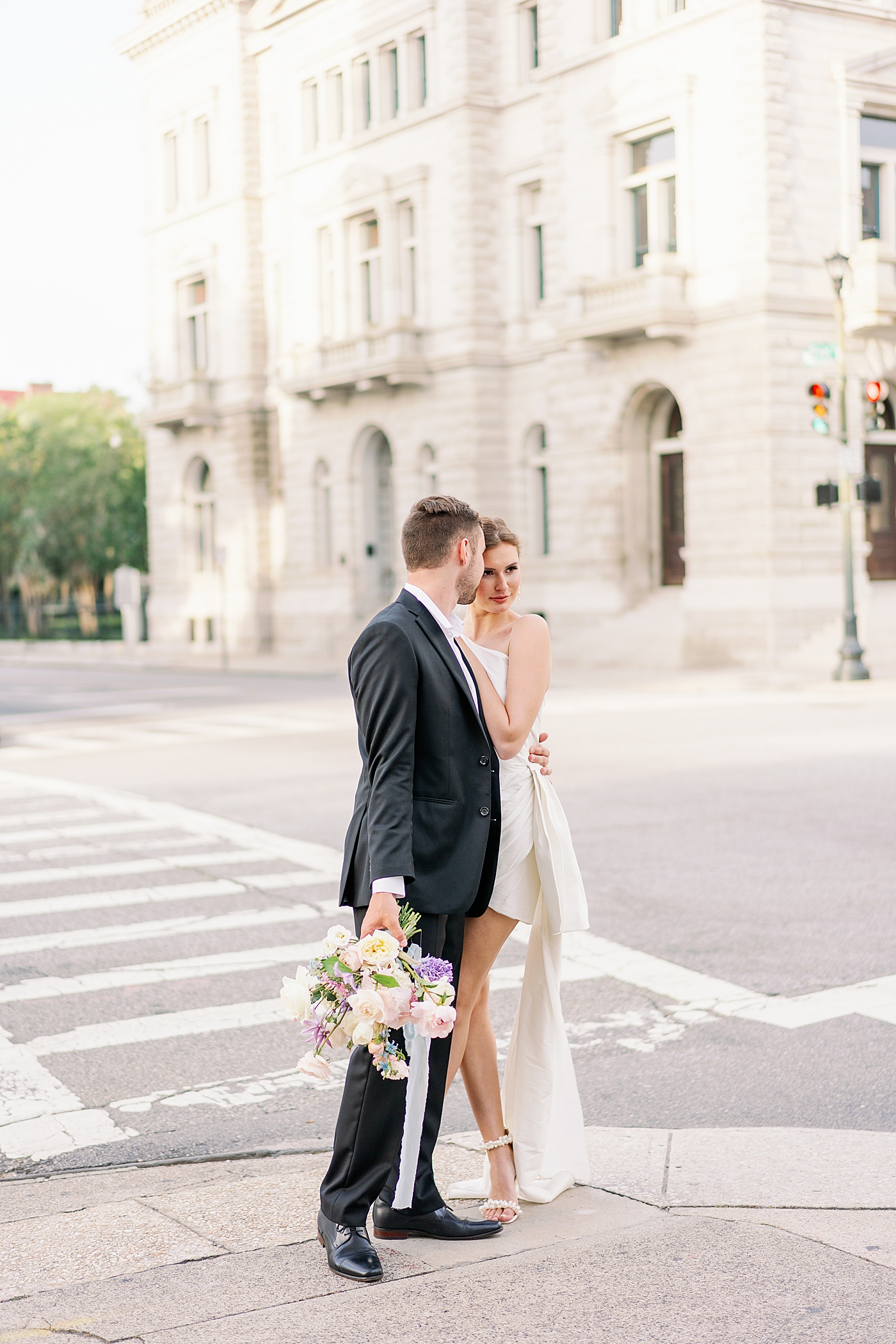 Bride and groom snuggling at crosswalk in Charleston | Images by Annie Laura Photo
