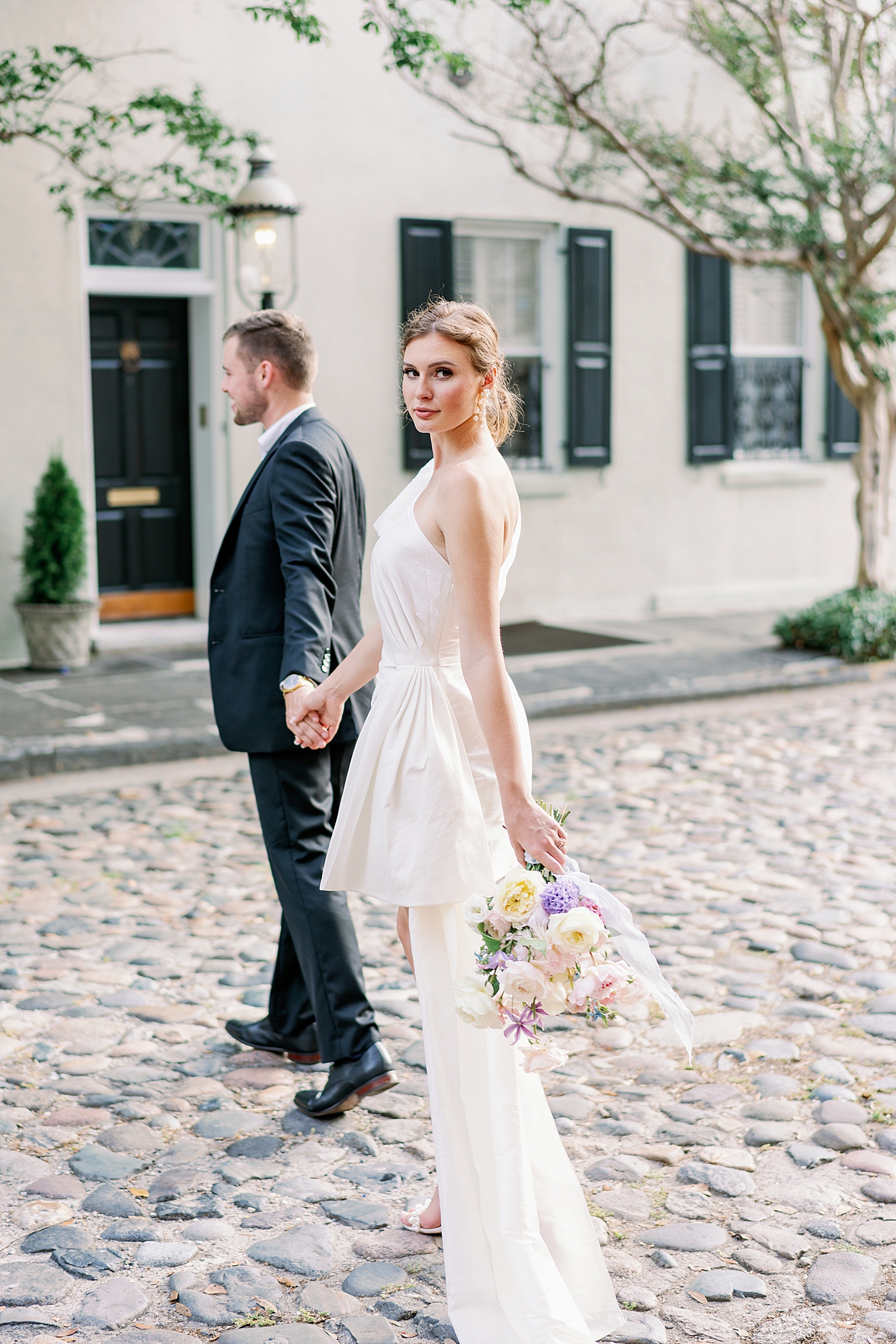 Bride and groom walking on cobblestone st | Images by Annie Laura Photo