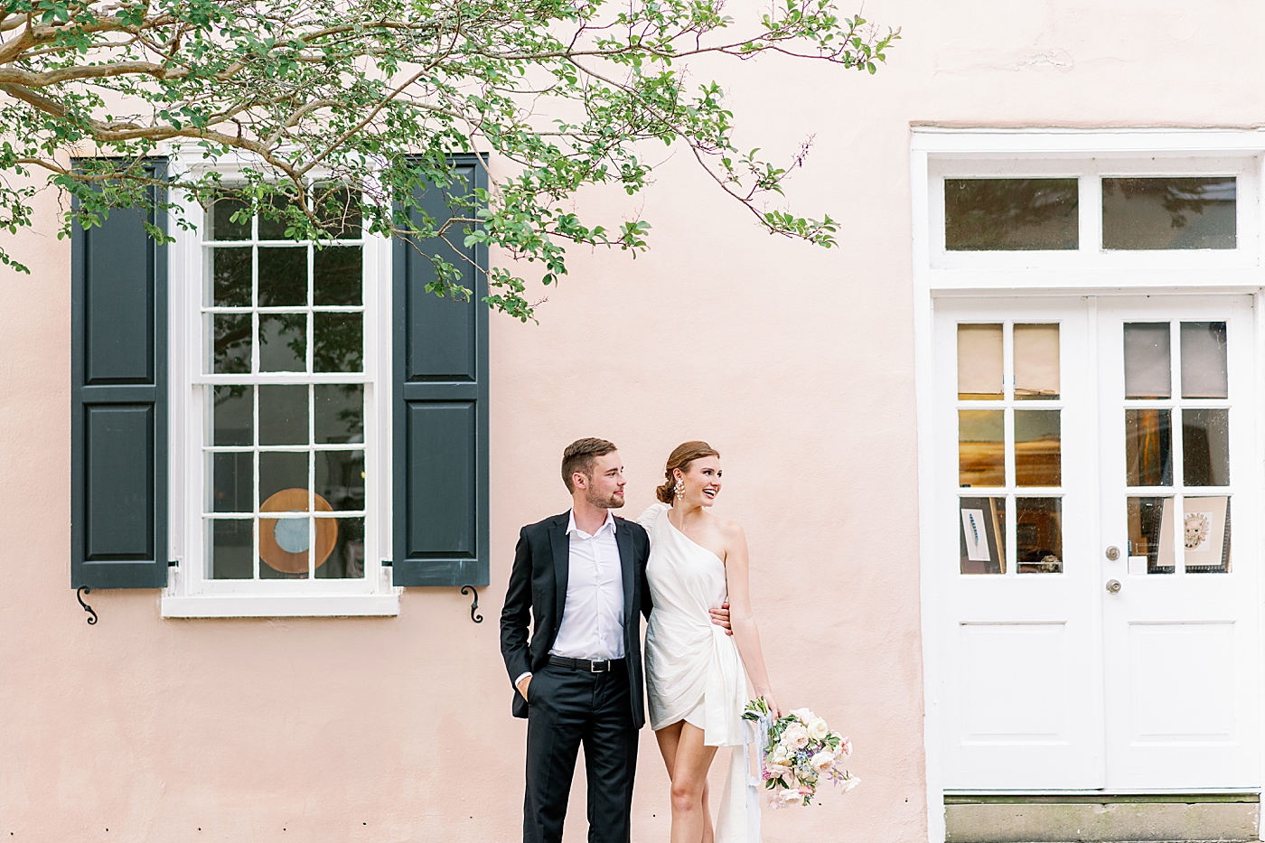 Couple posing together on Chalmers St in Charleston | Images by Annie Laura Photo