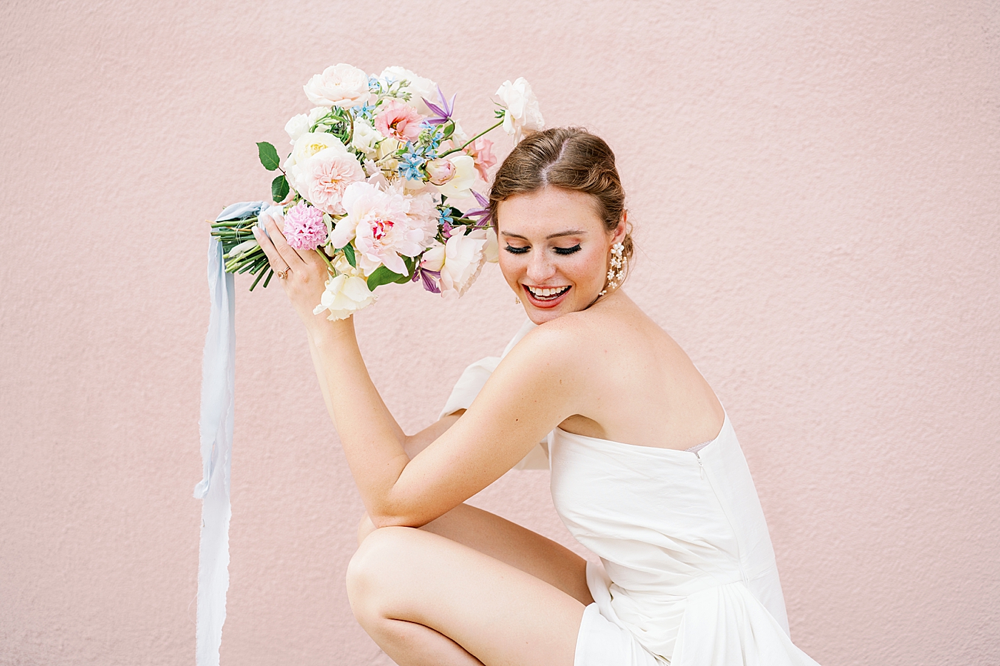 Bride smiling holding a bouquet of flowers | Images by Annie Laura Photo