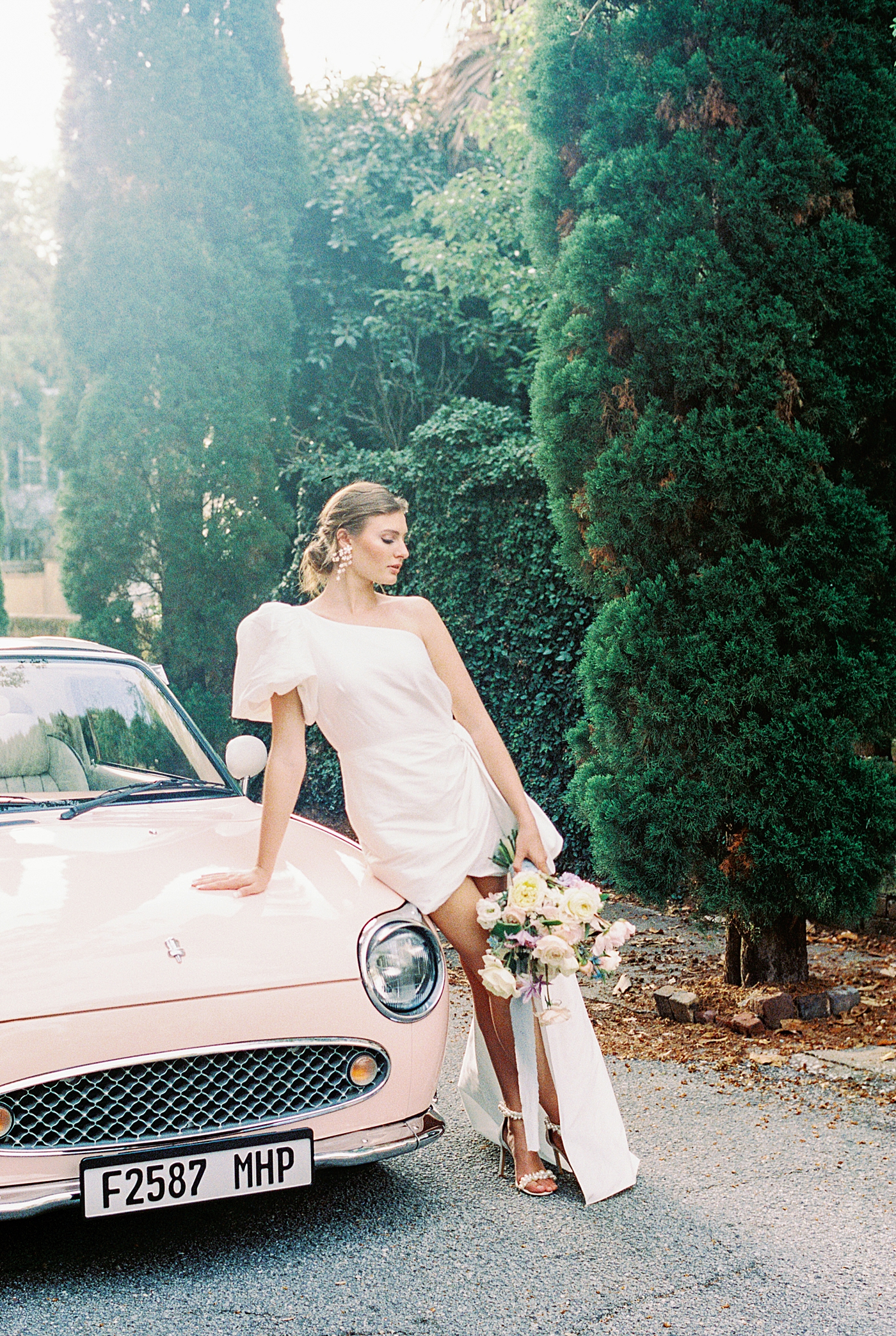 Bride posing near pink car during Elevated City Hall Elopement in Charleston | Images by Annie Laura Photo