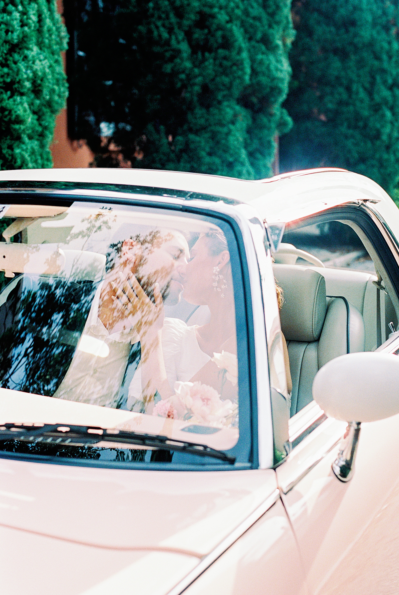 Bride and groom kissing in light pink car during Elevated City Hall Elopement in Charleston | Images by Annie Laura Photo