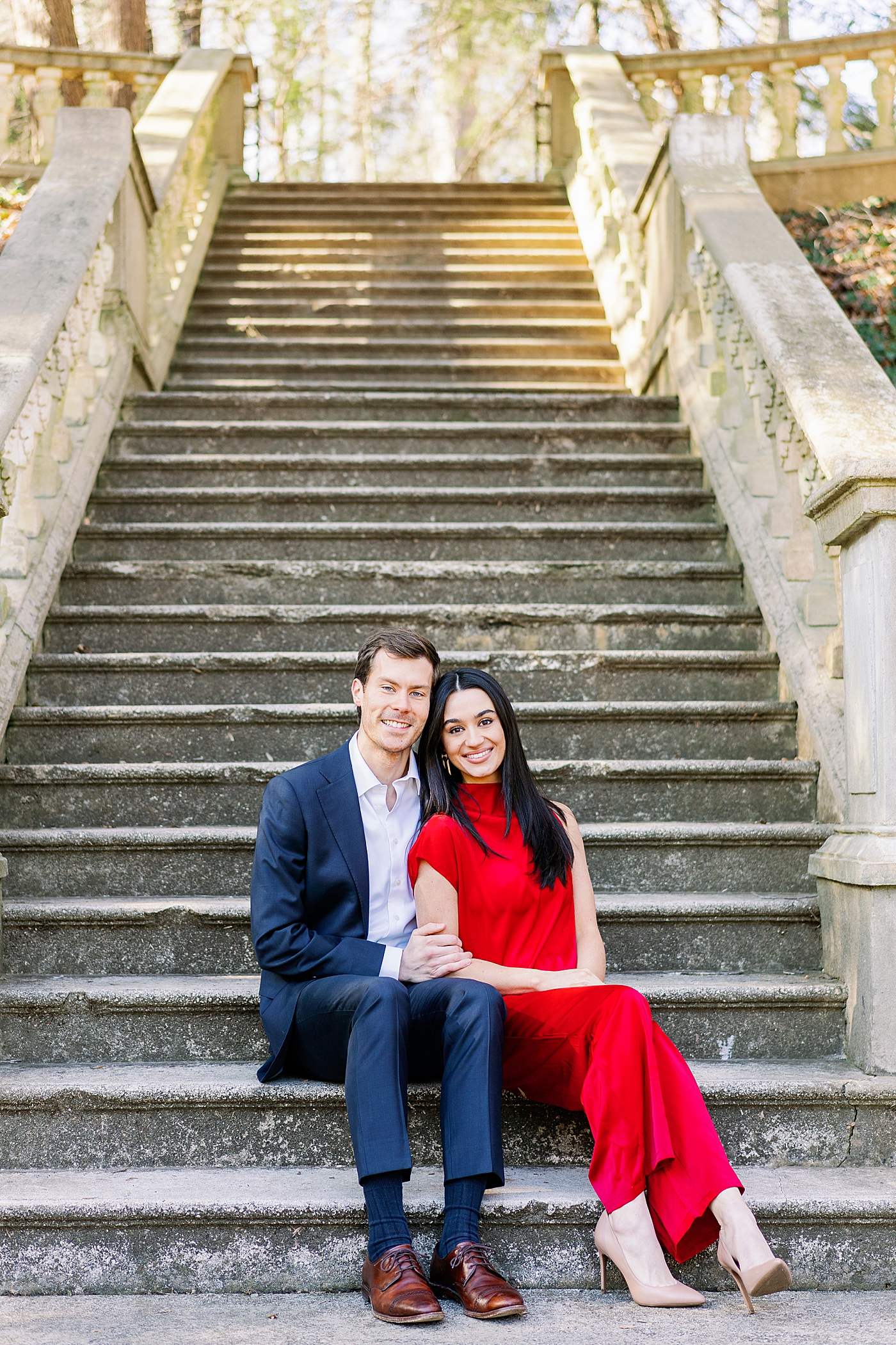 Engaged couple sitting on stone staircase | Image by Annie Laura Photo