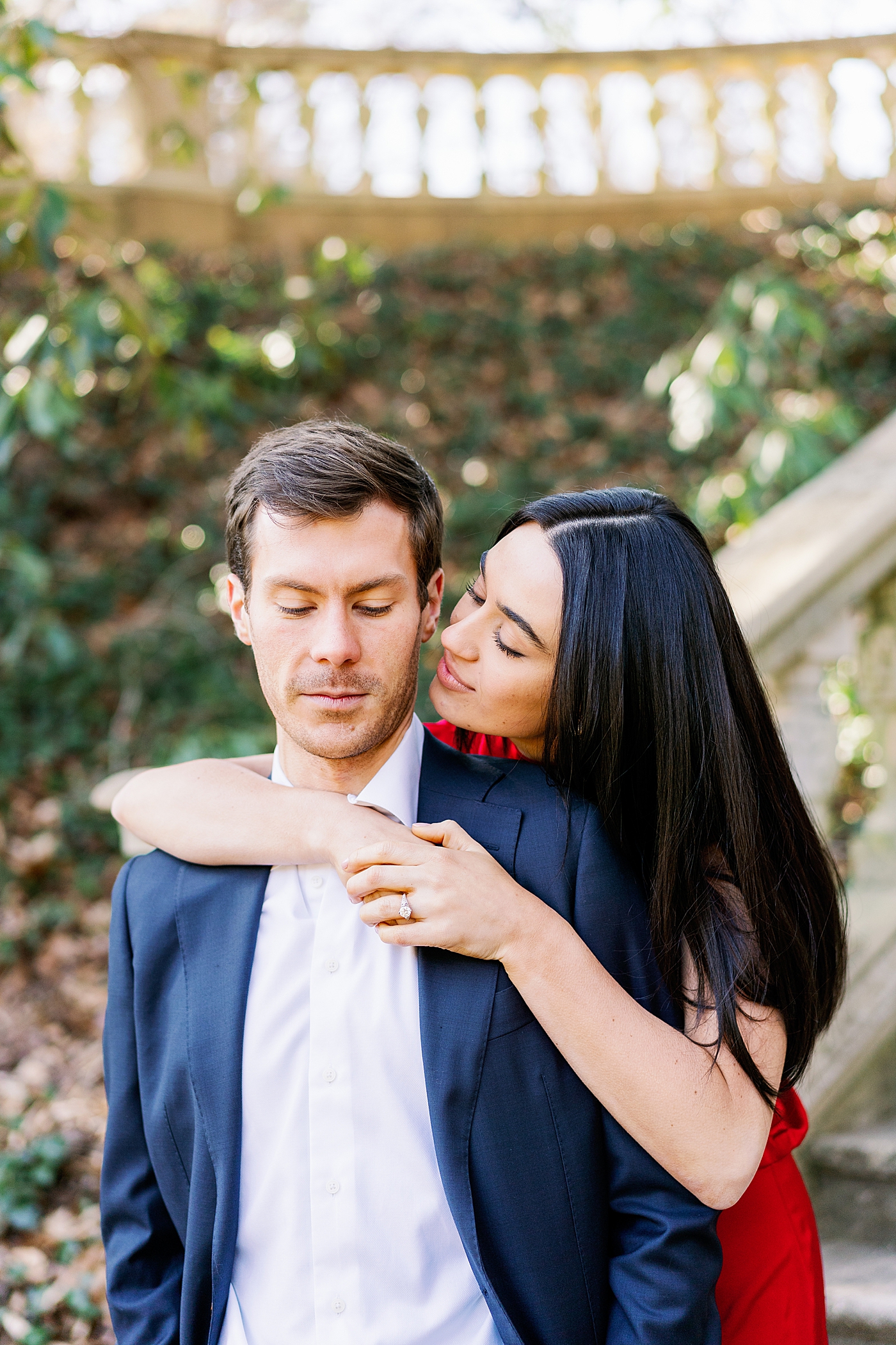 Couple in red and blue during their Atlanta, GA Garden Engagement | Image by Annie Laura Photo