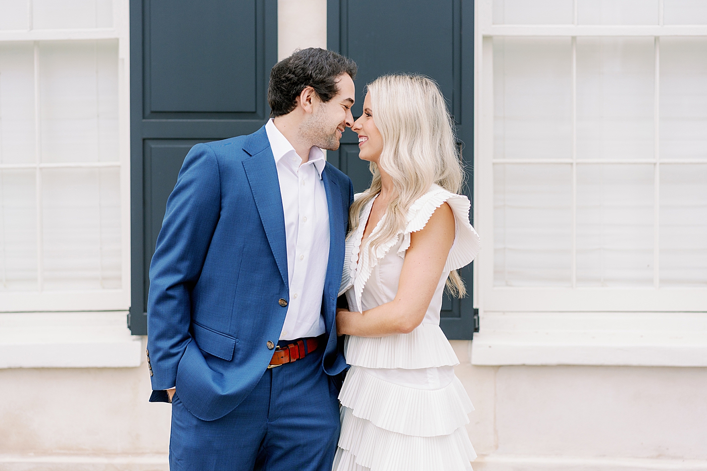 Couple with their noses together in front of pink building | Intimate Charleston Engagement Session with Annie Laura Photo