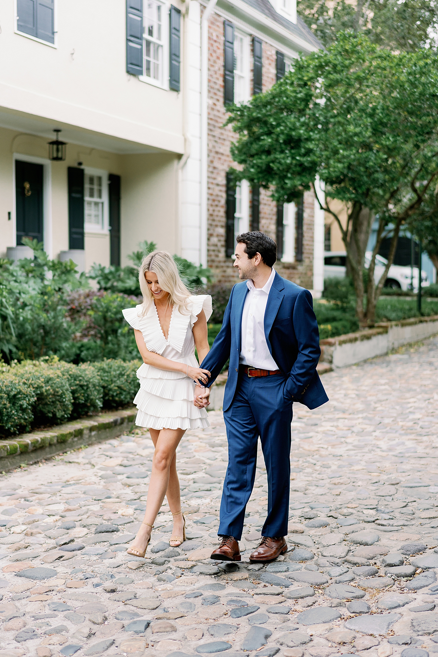 Couple holding hands walking on cobblestone street | Image by Annie Laura Photo