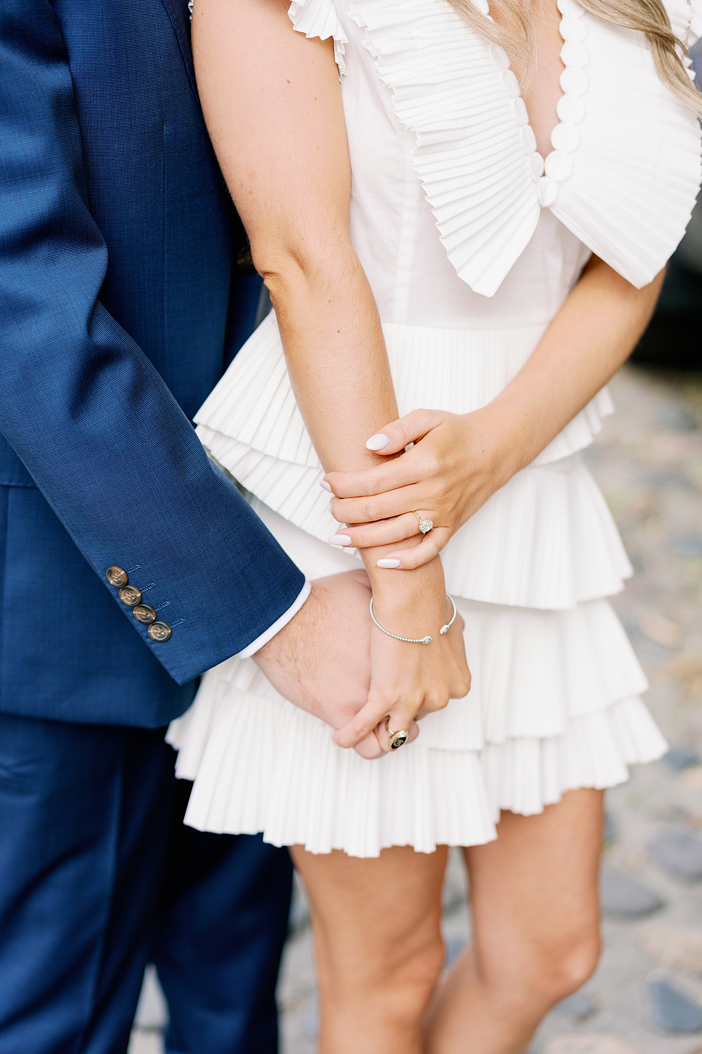 Detail of brides ring against grooms blue jacket | Image by Annie Laura Photo