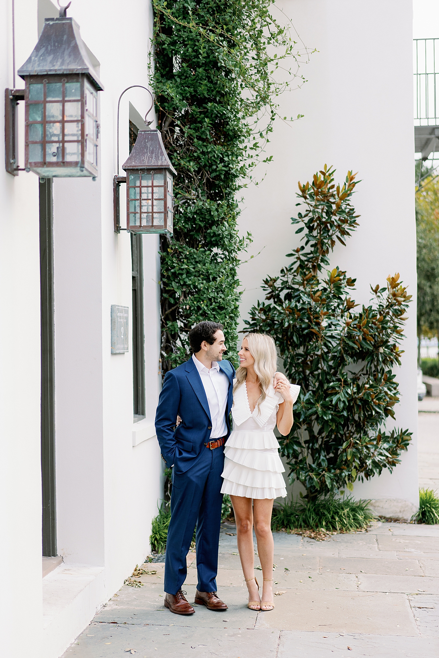 Couple posing in front of white building | Image by Annie Laura Photo