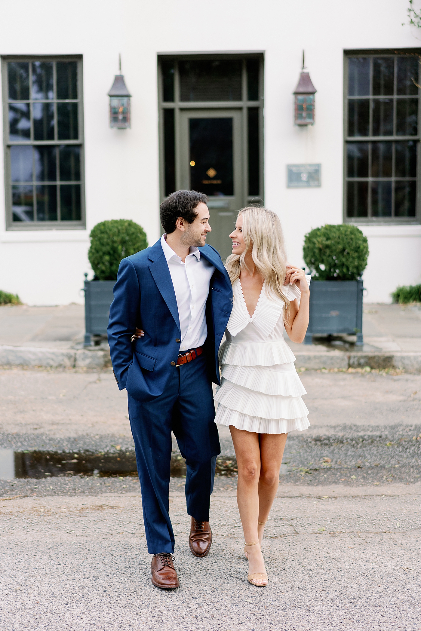 Couple smiling walking in front of white building | Image by Annie Laura Photo