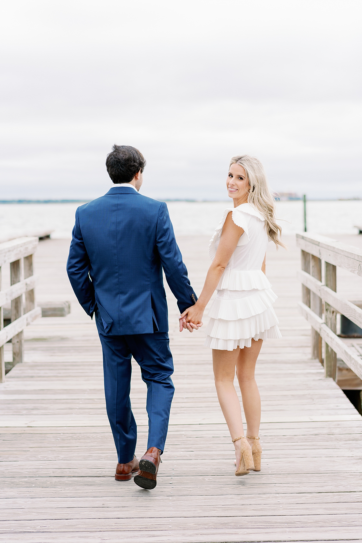 Couple walking on a pier holding hands | Image by Annie Laura Photo