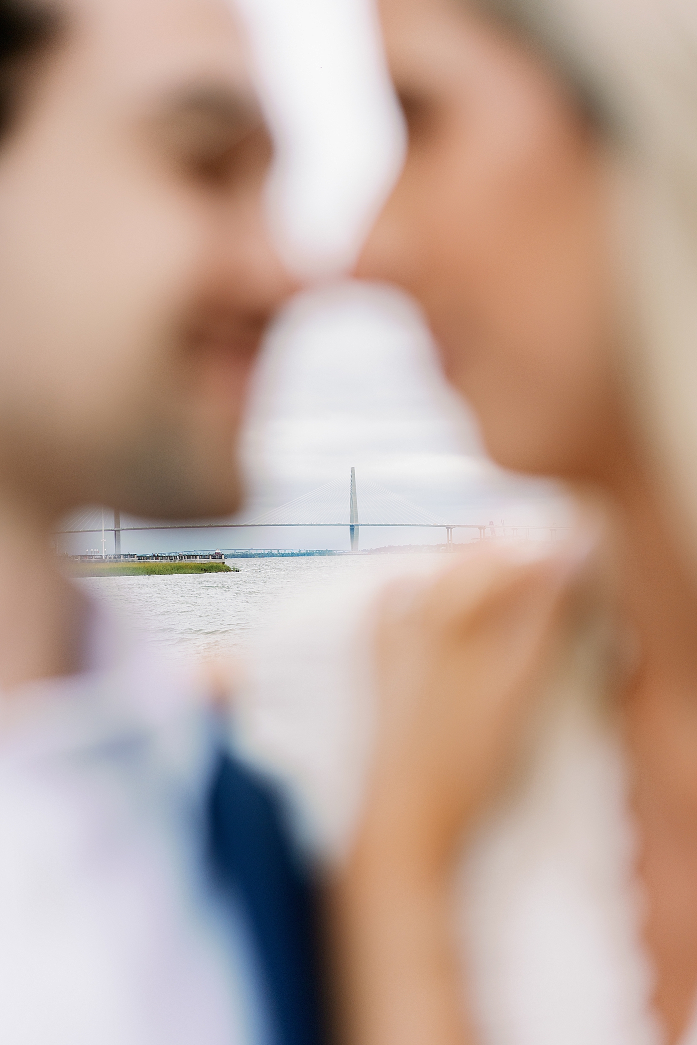 Couple with noses together blurred with charleston bridge in the background | Image by Annie Laura Photo