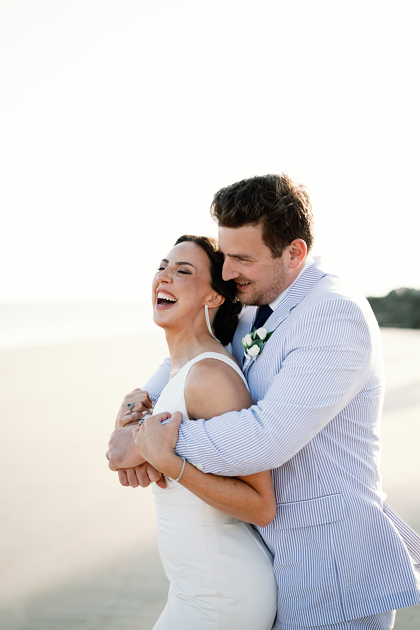 Bride and groom embracing on the beach | Image by Annie Laura Photo