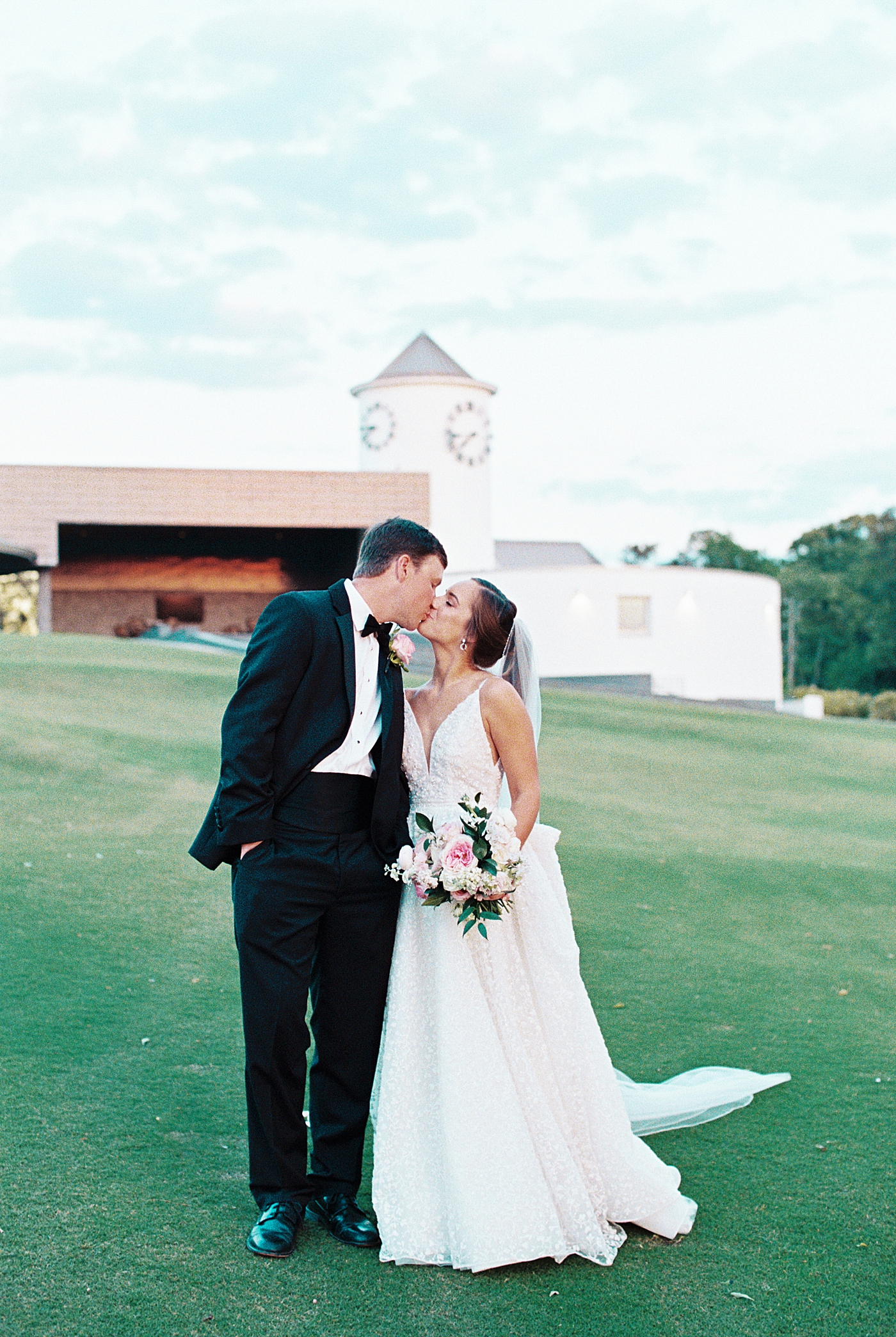 Bride and groom kissing near their wedding venue | Image by Annie Laura Photo